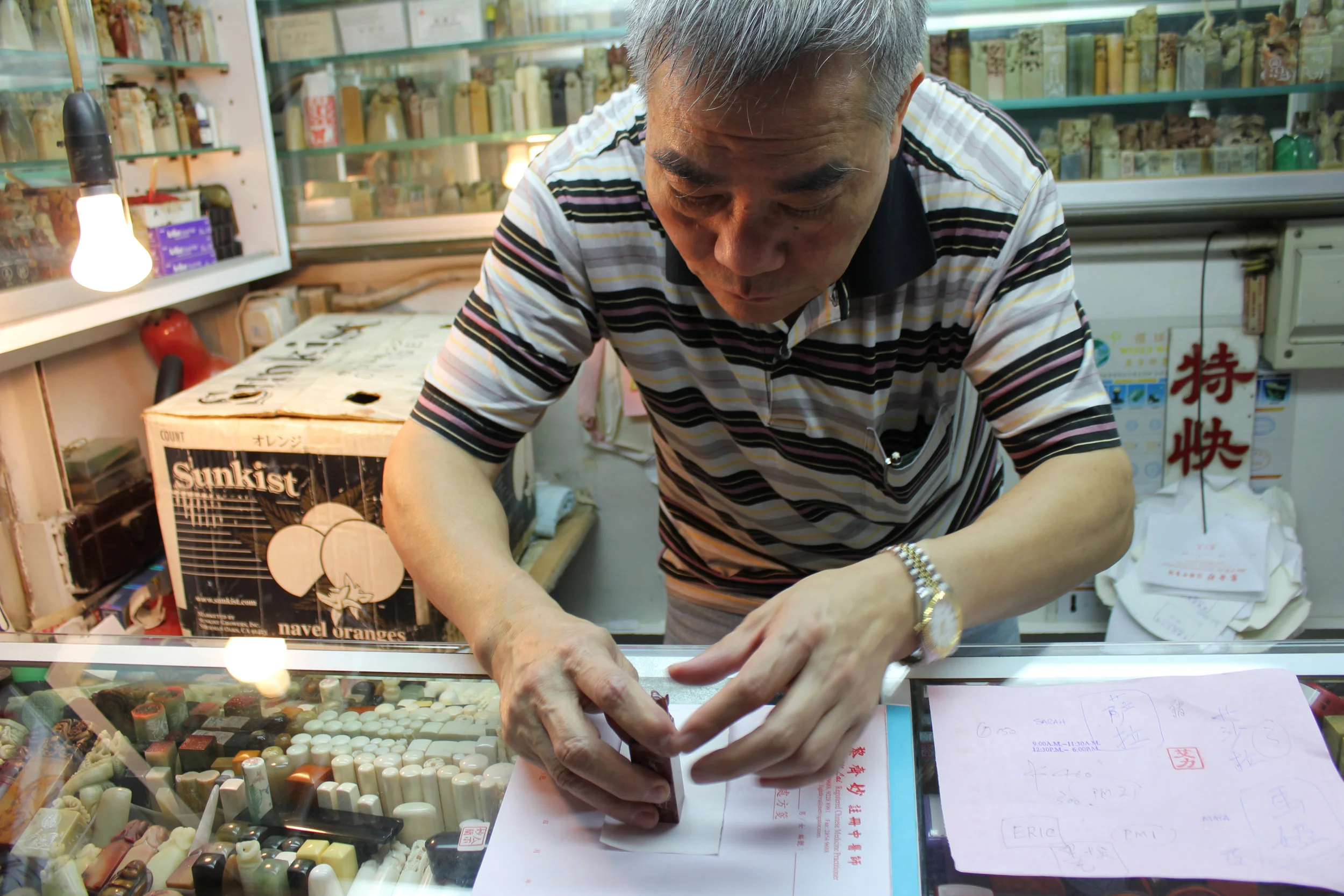 My "friend" the chop maker, surrounded by his wares, testing one of the chops made to order for me.