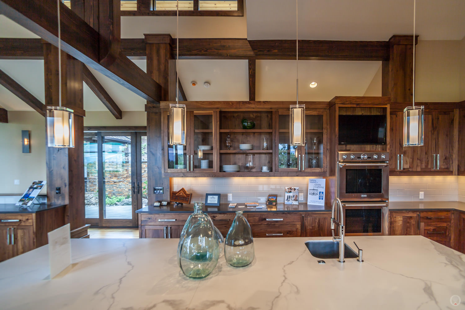 Pendant light fixtures. Also note: Shaker-style cabinets, stainless steel appliances, and subway tile backsplash.