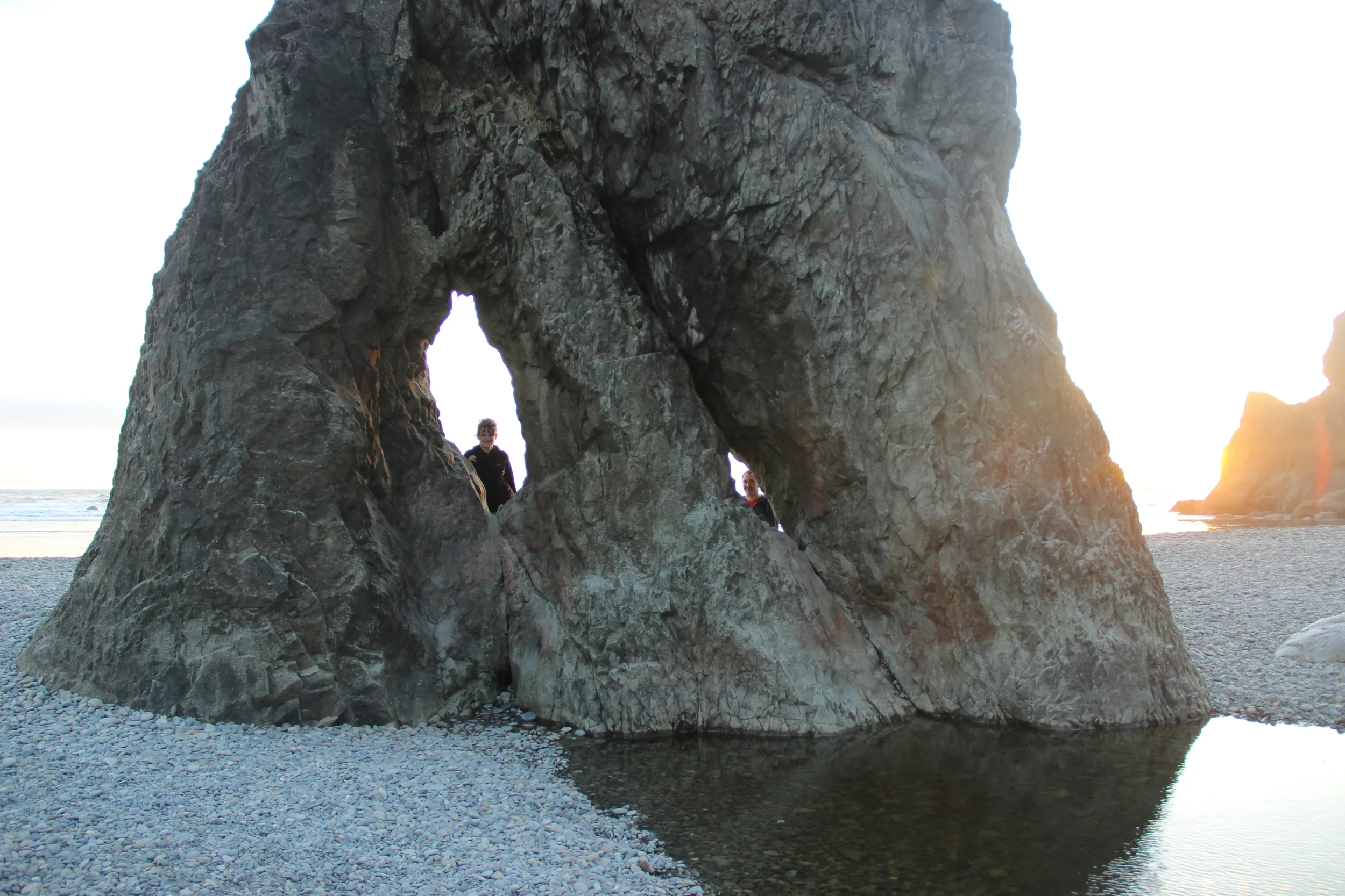 Julie and Jesse poking their faces through the rock.