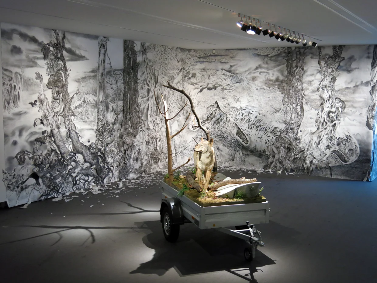 "Quagmire (Den Haag)" Ink, charcoal, graphite, gesso, watercolour and collaged paper on paper. 12' X 52'. 2013. Mark Dion's "Mobile Wilderness Unit" is in front.