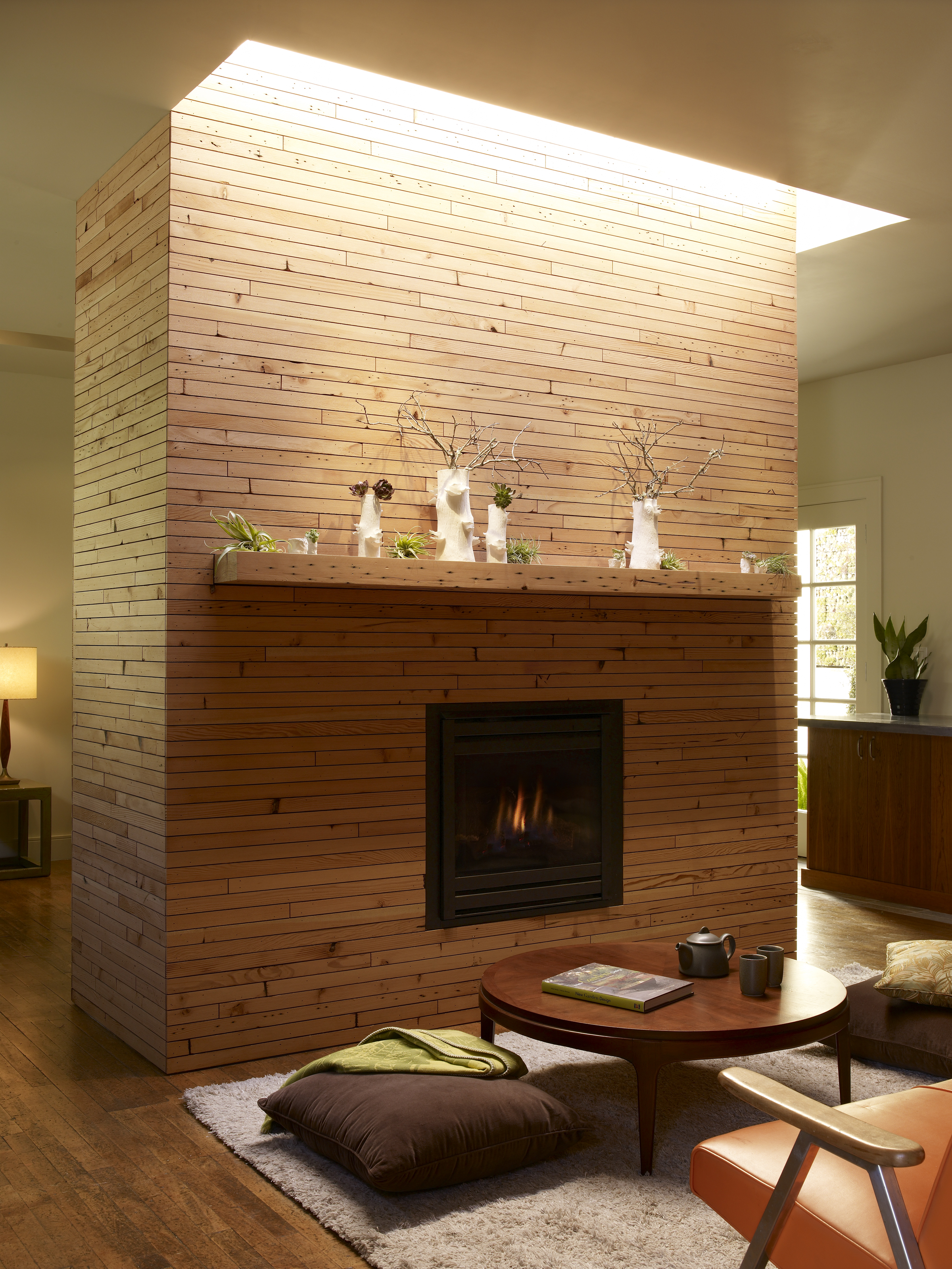 The fireplace is wrapped in 1/4″ x 1 1/2″ slats that were milled from the existing douglas fir roof joists before we raised the ceiling height and replaced the roof with engineered trusses.