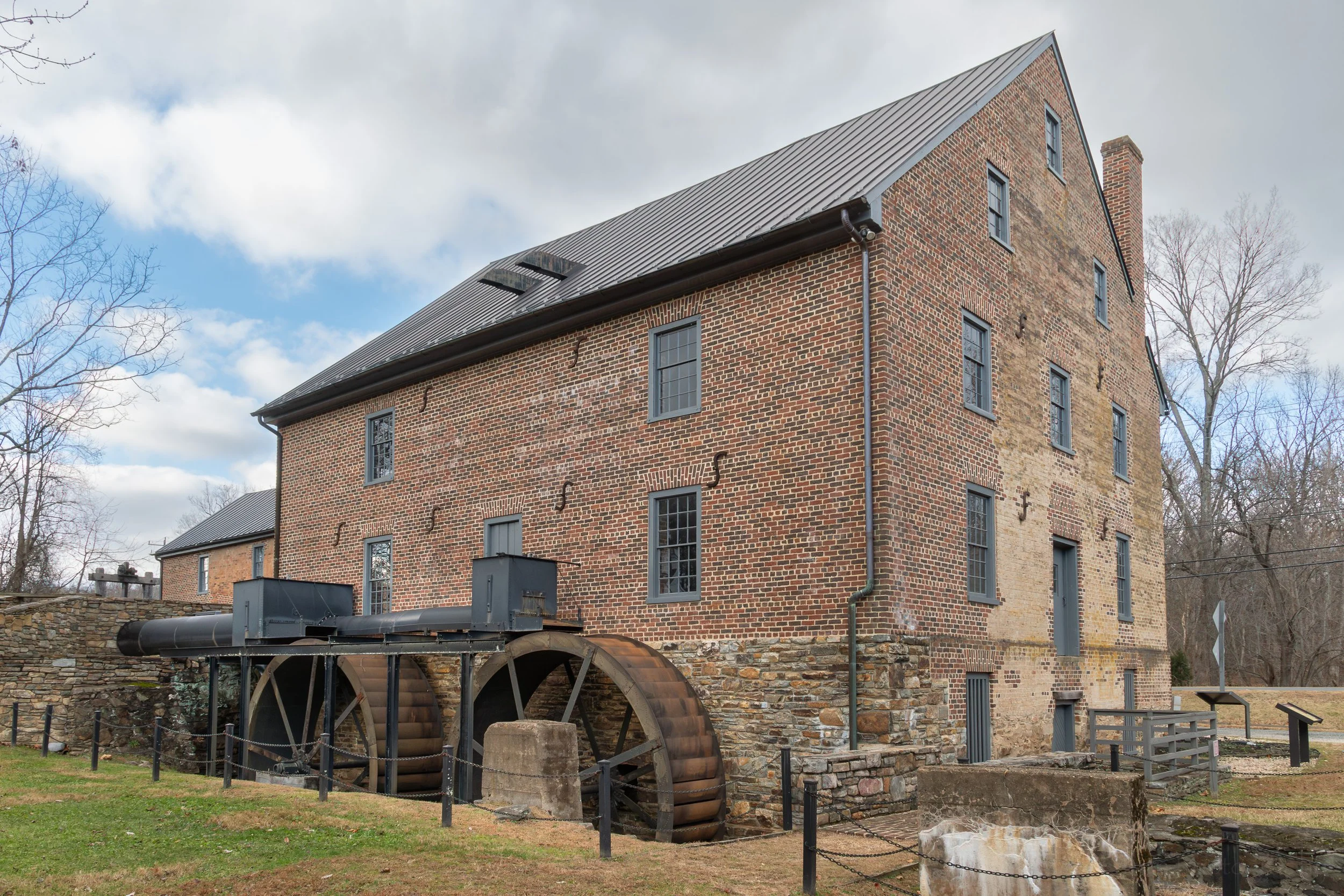 The back of the merchant mill at Aldie Mill, showing the water wheels and the granary in the background
