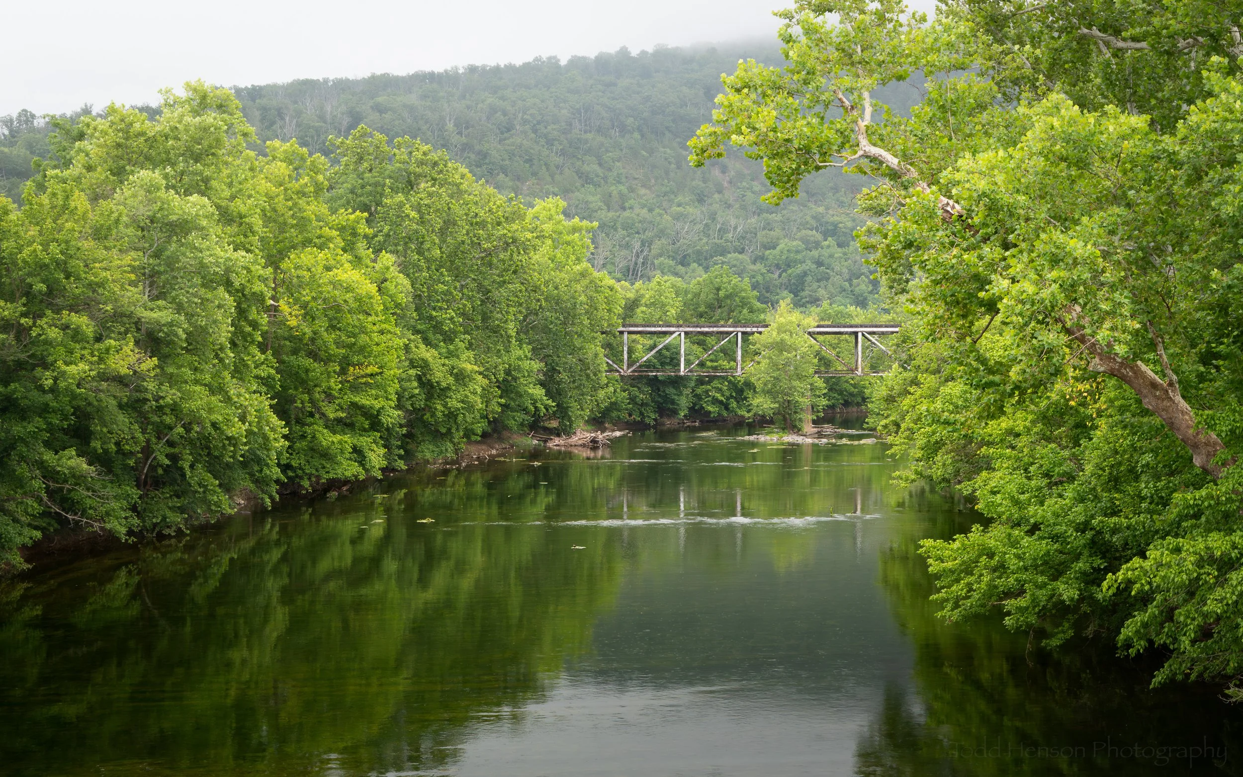 An old railroad bridge over North Fork Shenandoah River with the slopes of Signal Knob in the background