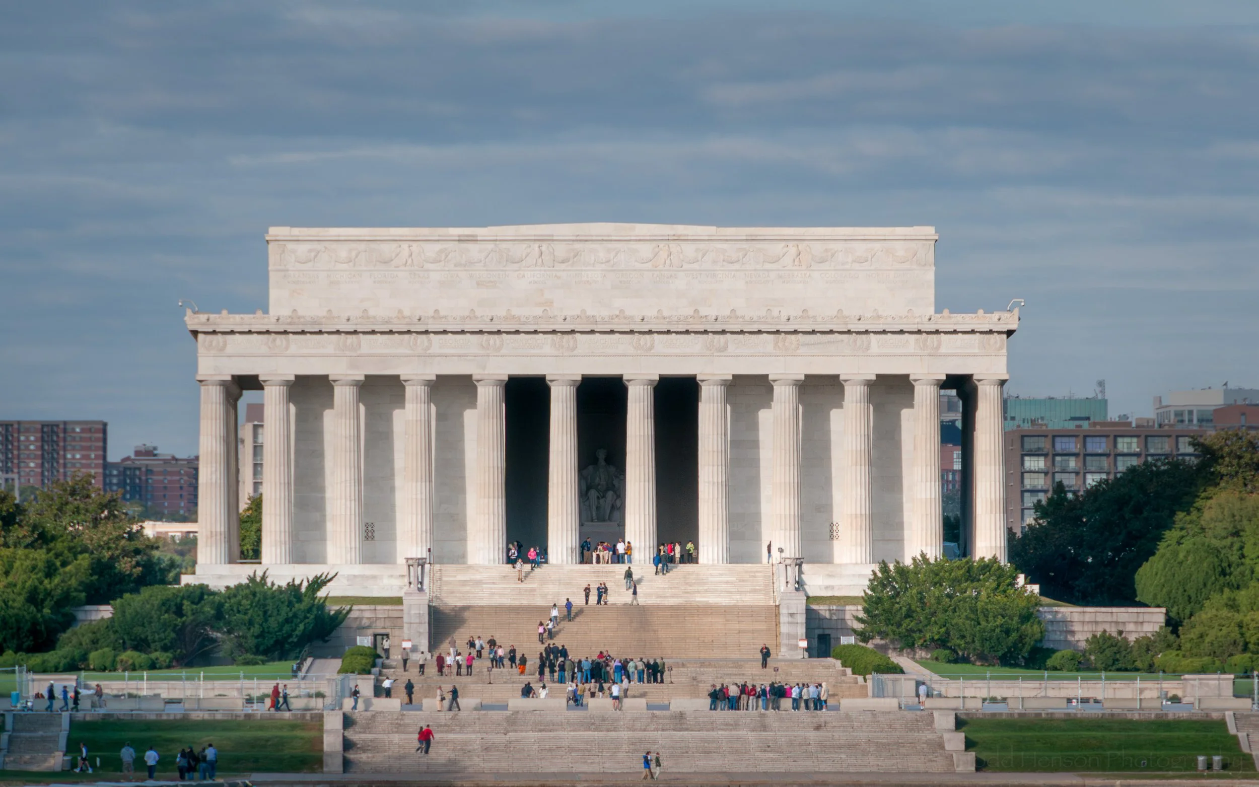 The sun lights up the Lincoln Memorial on a cloudy day in Washington DC.