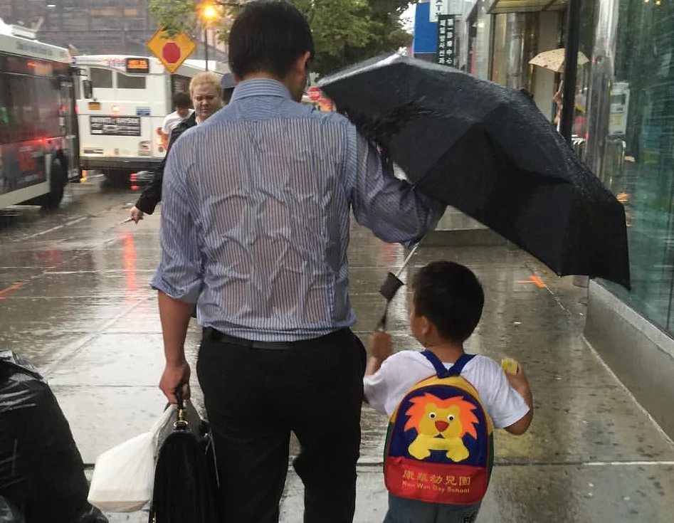 'Umbrella Dad' Gets Soaked In The Rain To Keep His Son Dry