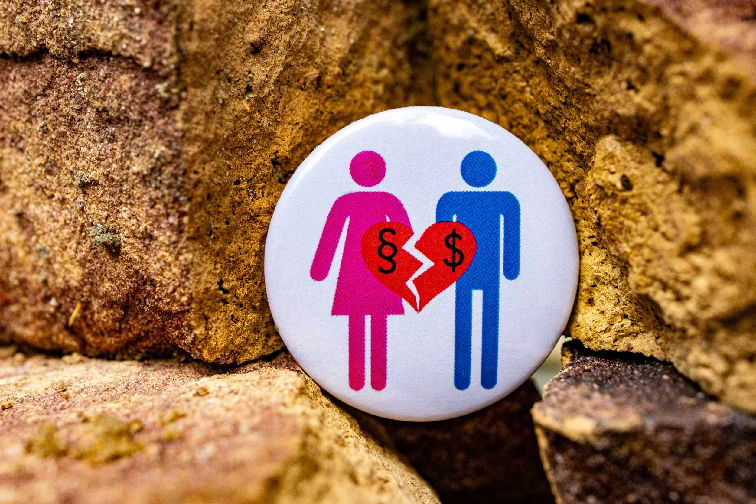 A button with a picture of a man and a woman holding a heart Divorce dispute over the property