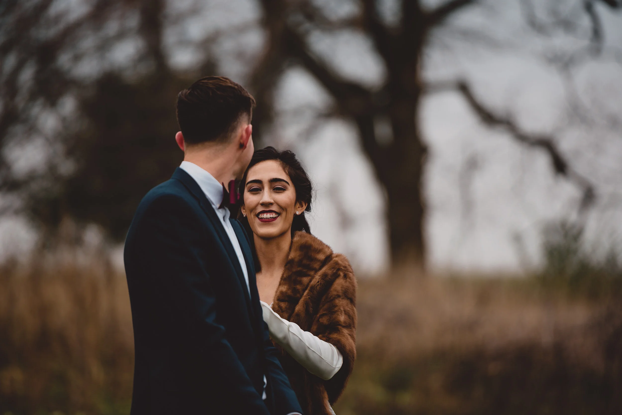 bride and groom first look bride in vintage white and brown fur groom in navy and bowtie.jpg