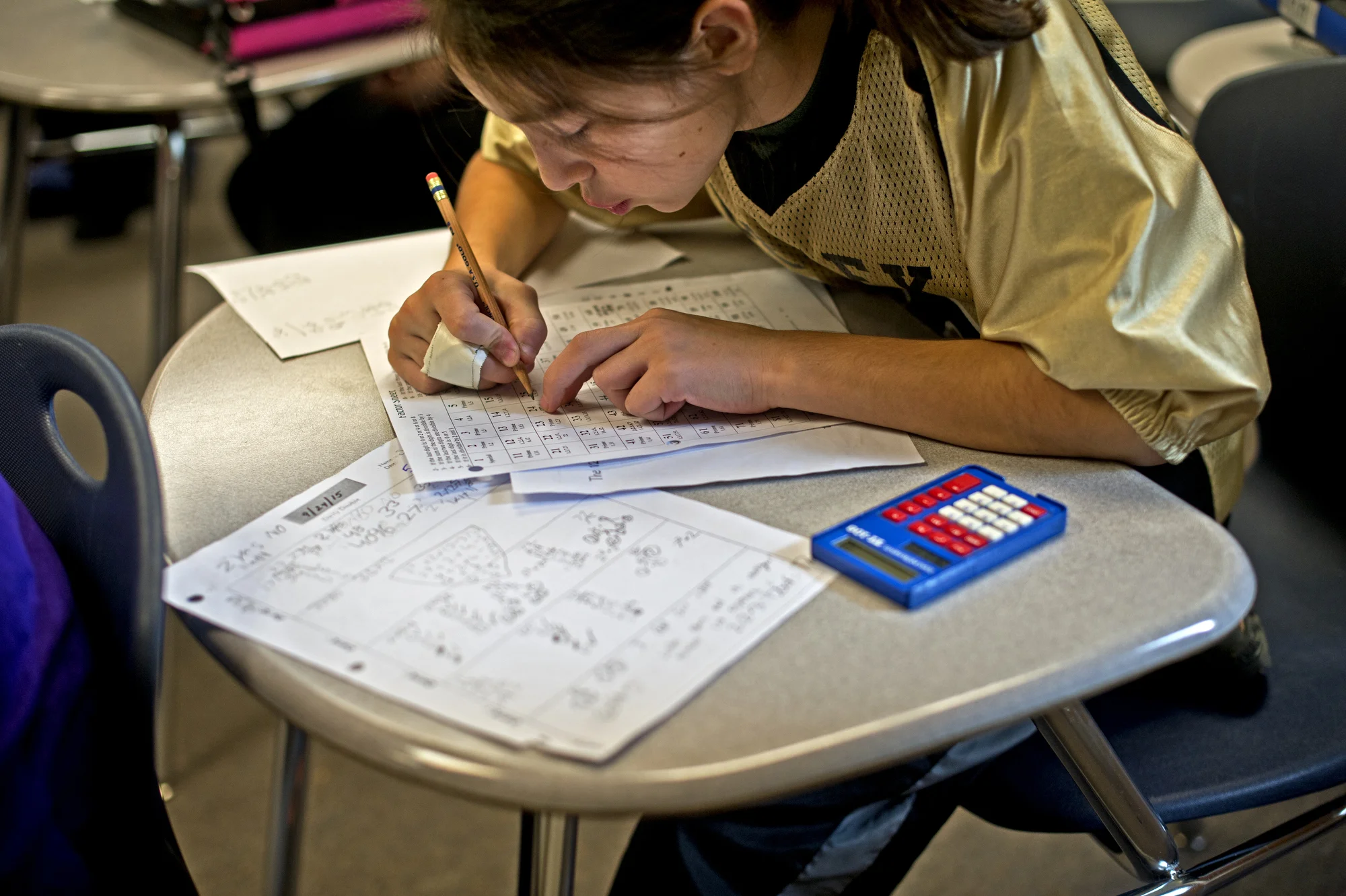  Sophie works on an assignment despite a football-related injury during Mr. Dale Laughner's math class on Oct. 16 at Bullock Creek Middle School in Midland, Mich. Math is one of her favorite subjects. Sophie jammed her fingers during practice that we