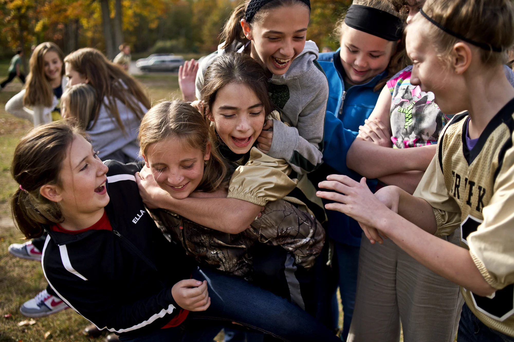  From left, Bullock Creek middle schoolers Ella Dufort, Hillary Anderson, Sophie, Rita Grouch, Alana Chadwick, Neveah Moore and Ashley Fleming, give each other piggyback rides during recess on Oct. 16 Midland, Mich. Football players wear their jersey