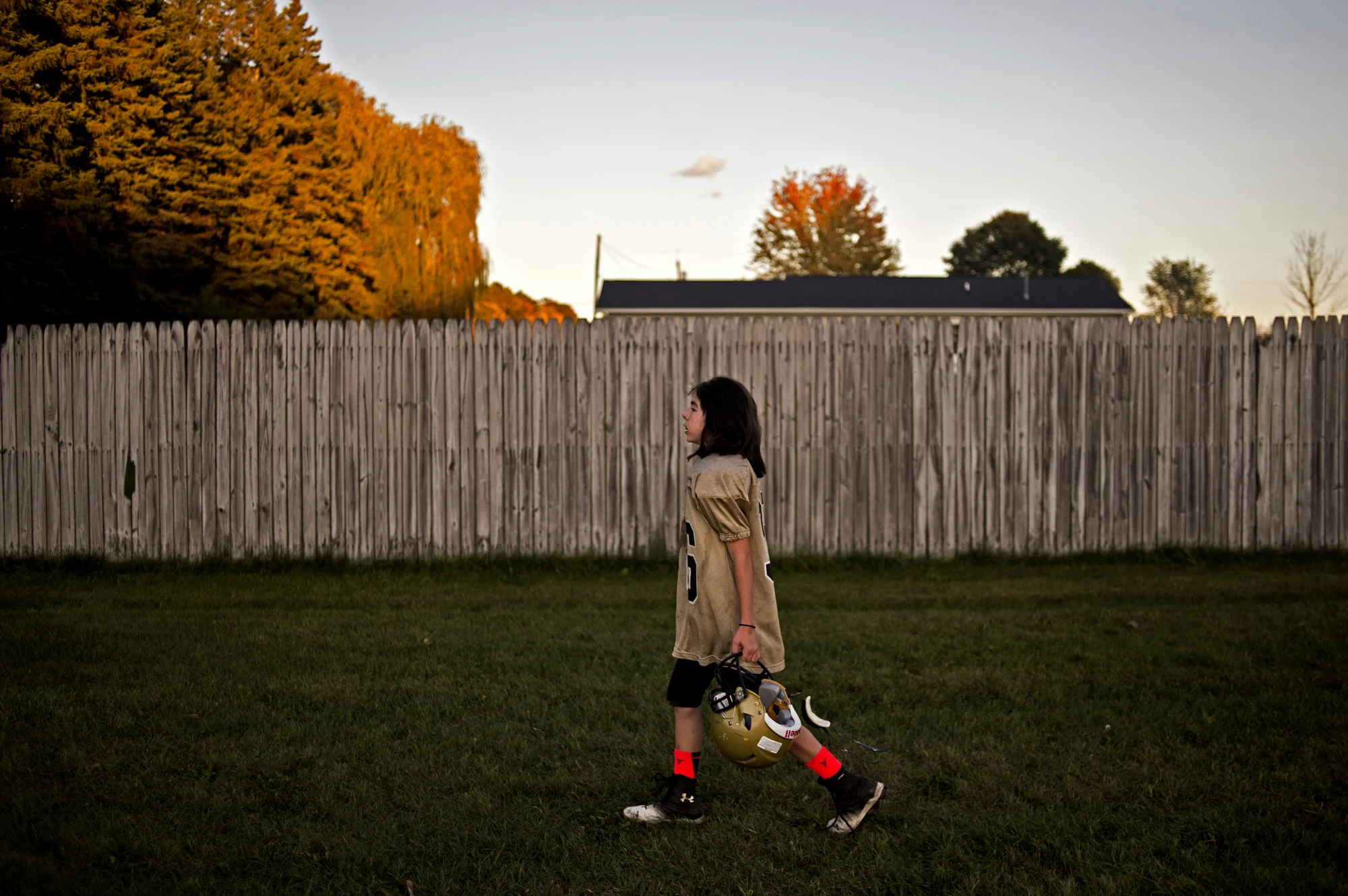  Sophie holds her helmet as she walks behind her teammates to a scrimmage against the Bullock Creek Youth League Program Fifth-Grade Team on Oct. 14 in Midland, Mich. 