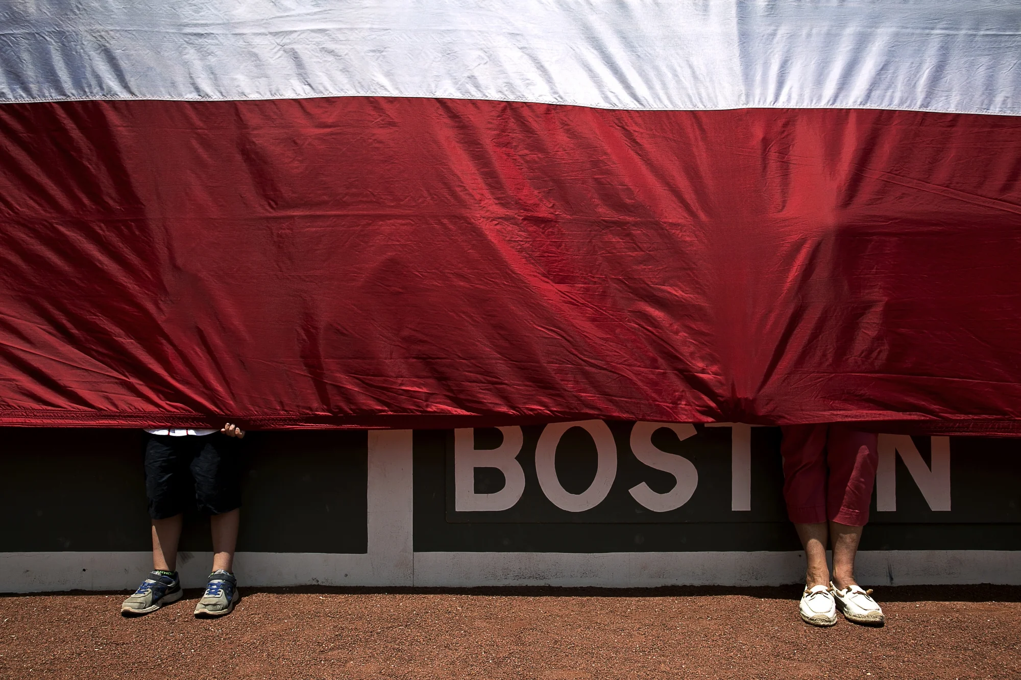  Volunteers hold the flag over the Green Monster scoreboard during the National Anthem before the Boston Red Sox vs. Baltimore Orioles game at Fenway Park on Thursday, June 25, 2015 in Boston, Mass. 