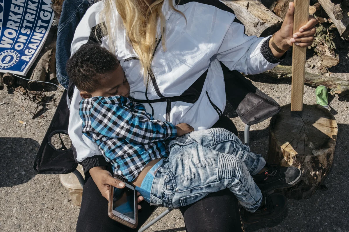  General Motors temporary employee Shaquala Watson, 27, of Burton holds onto her sleeping son Rylan Hurt, 2, while picketing outside the General Motors Flint Assembly Plant during the 11th day of the strike on Thursday, Sep. 26, 2019 in Flint, Mich. 