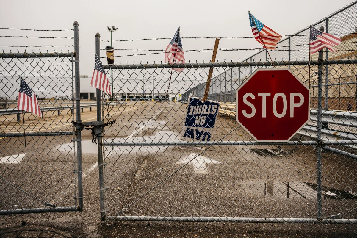  American flags hang on a fence outside the General Motors Flint Assembly Plant during the 18th day of the strike on Thursday, Oct. 3, 2019 in Flint, Mich.    