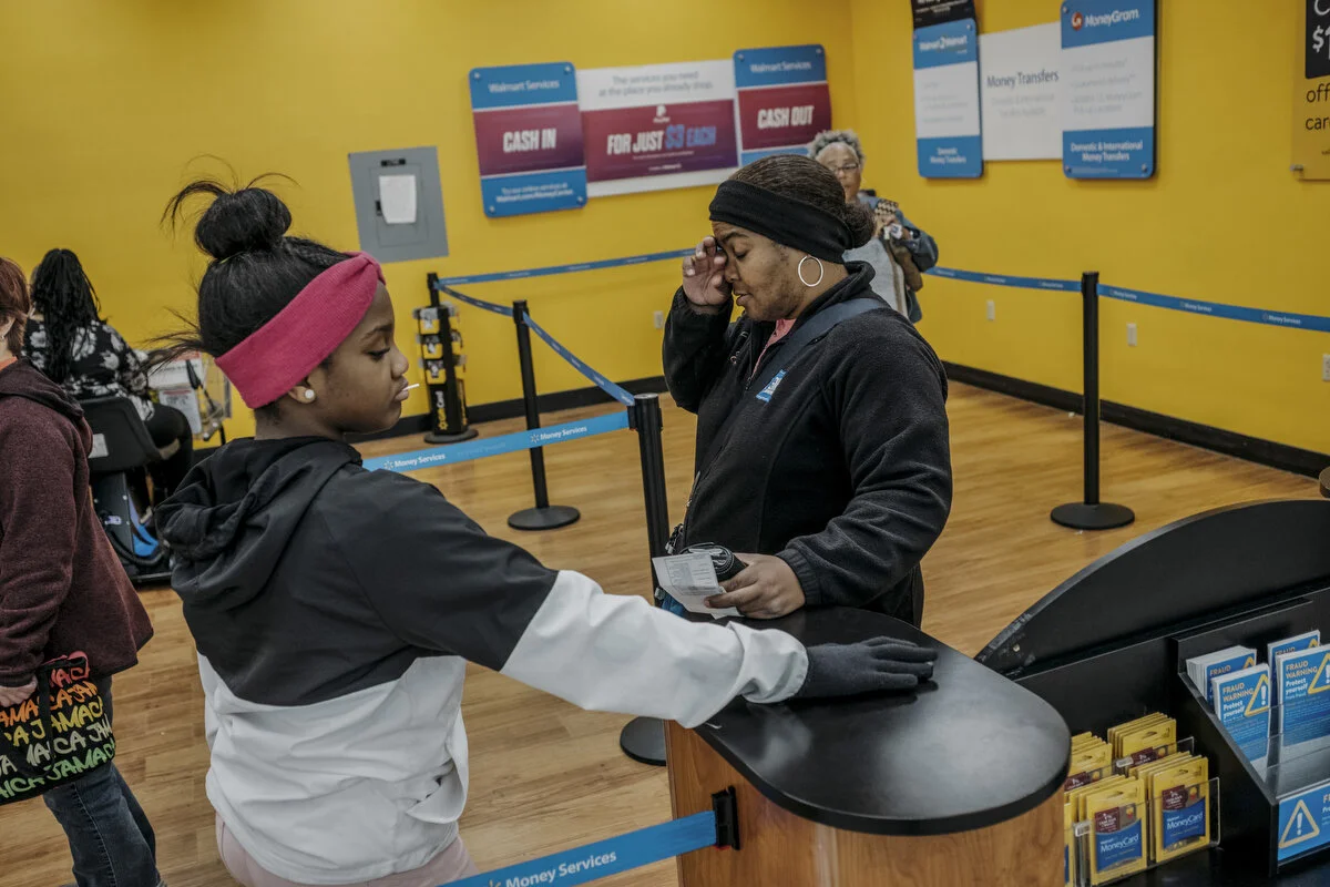  General Motors employee Erica Thompson, 46, and daughter Jasmine Thompson, 11, wait to cash her strike check at Walmart on Sunday, Oct. 13, 2019 in Flint, Mich.  During the strike she and her family have been budgeting and have eliminated weekly din