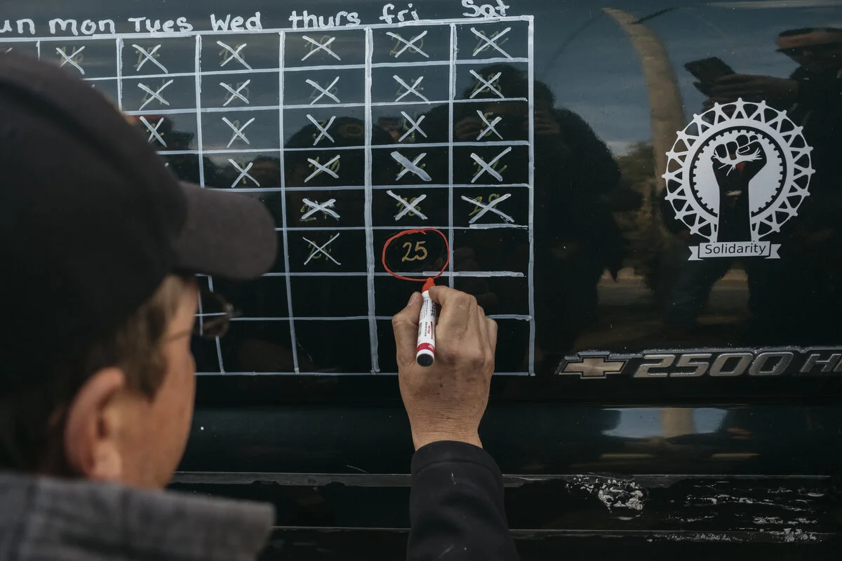  UAW Local 598 alternate committee man Bo Browning, 39, circles the last day of the strike on the door calendar outside Flint Assembly on Friday, Oct. 25, 2019 in Flint, Mich. The new UAW GM contract has been ratified. 