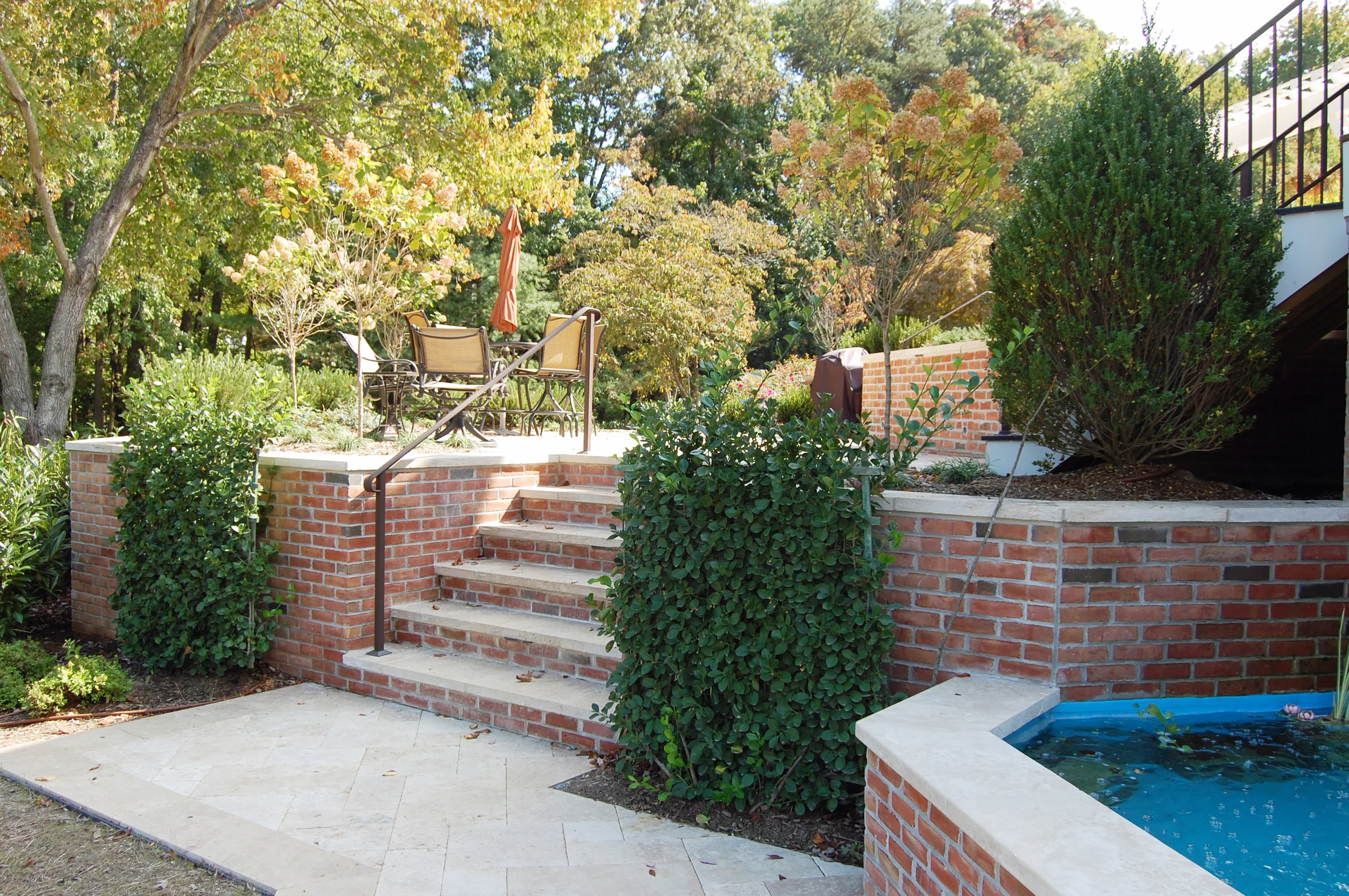 Brick walls and travertine step landings to the lower level.