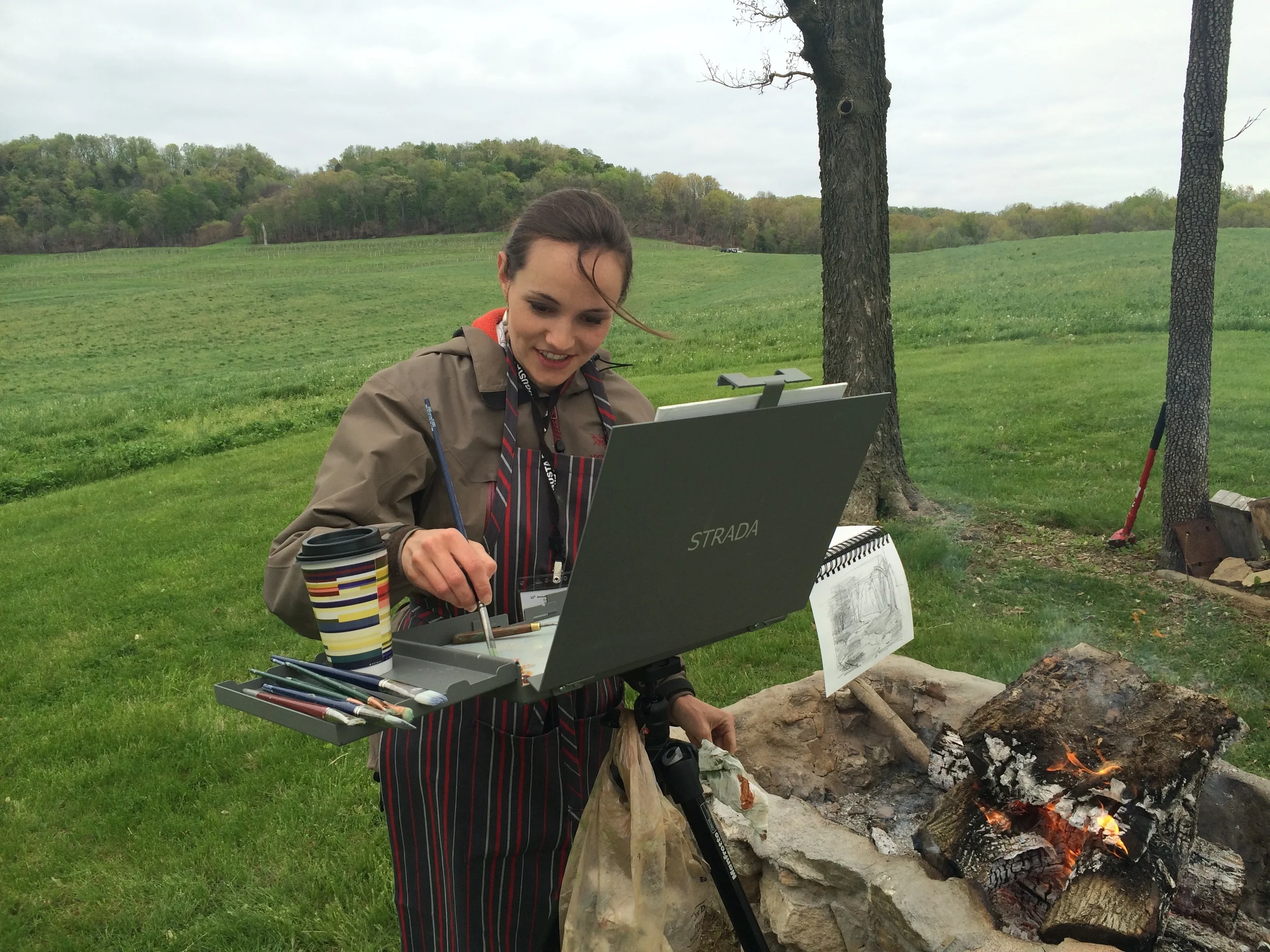 Staying warm. There was a downside to this spot, though: a few minutes after a fellow artist snapped this photo, my sketchbook took a dive into the firepit! Oops.