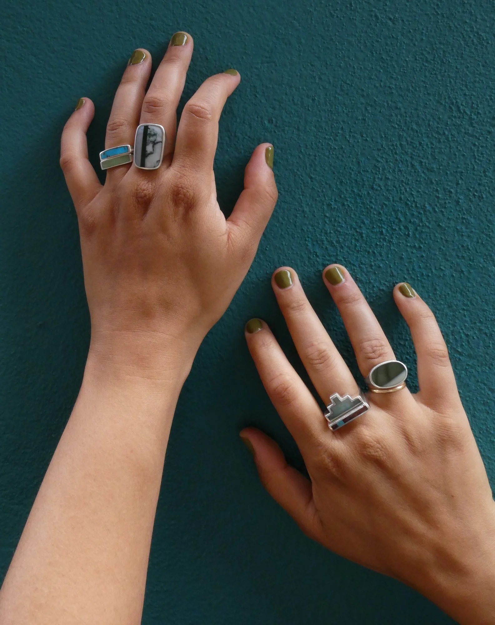 rings on hands teal background.JPG