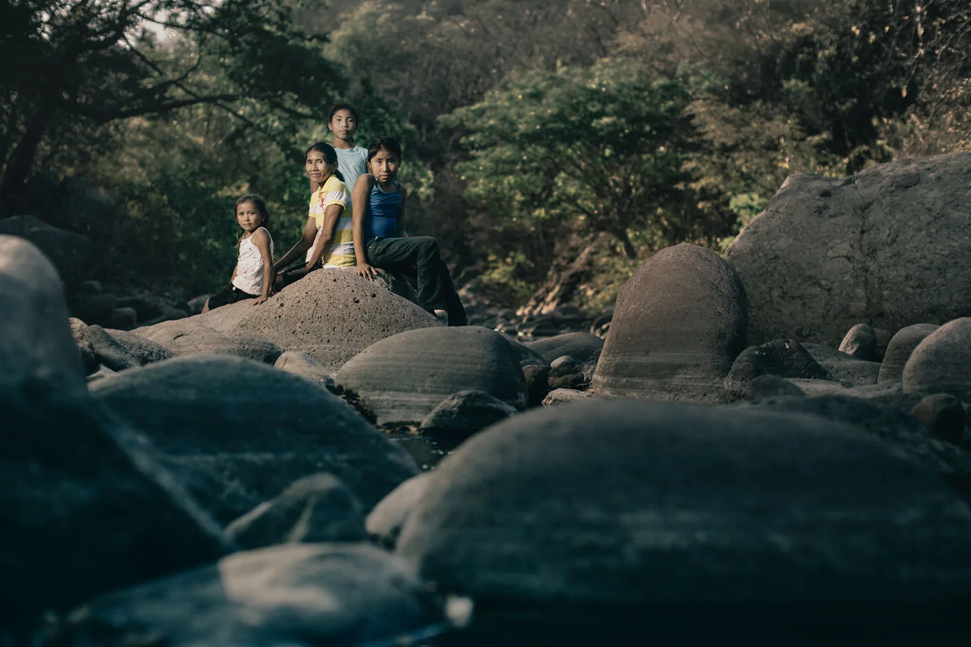 Maria with her mother and her siblings on the bank of a river near her house, the place where she likes to read and learn.