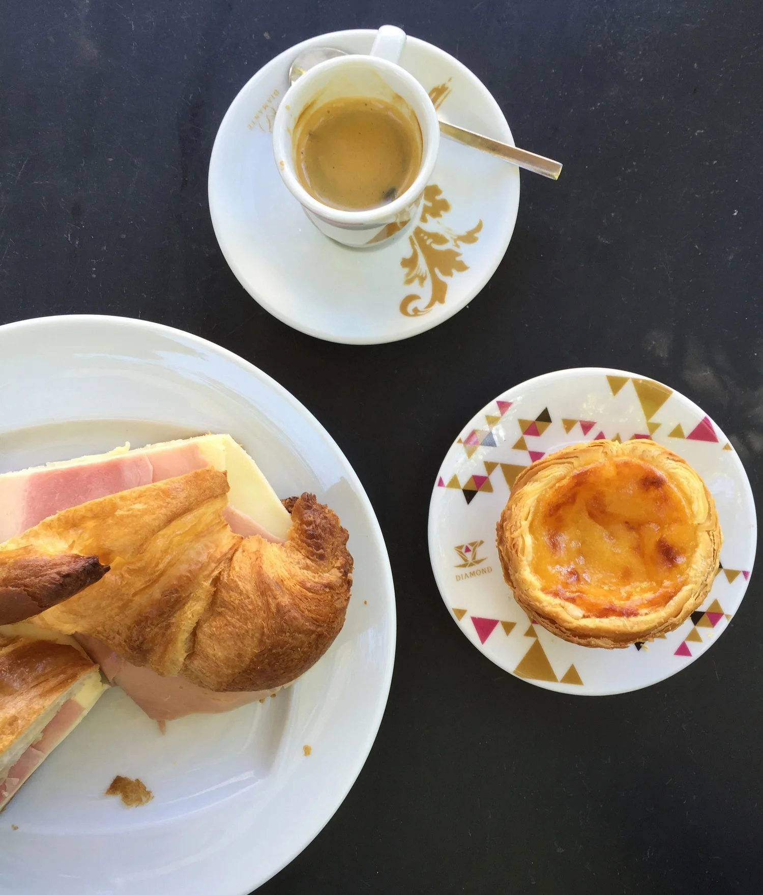 Espresso, pastel de nata with a sprinkle of cinnamon, and a ham and cheese croissant. Portuguese cheese is some of the best I've ever tasted.