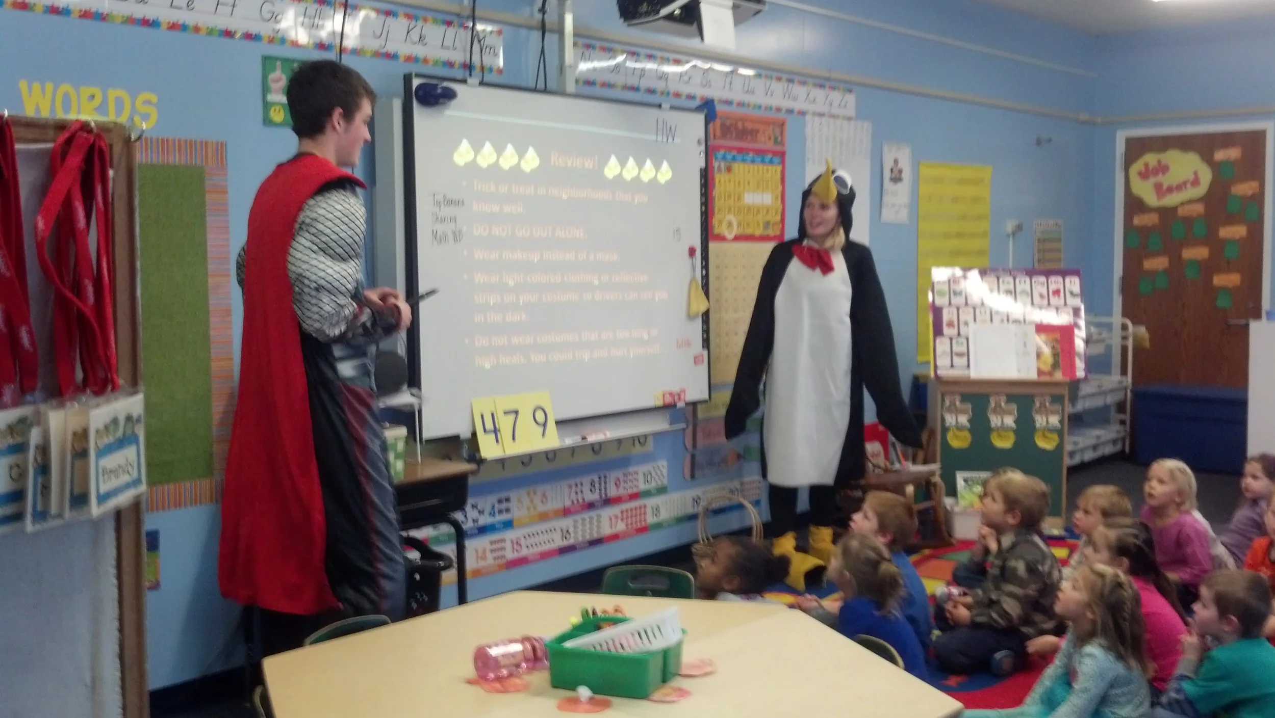 Dressed in their Halloween costumes, Wadena-Deer Creek BPA members Matthew Quincer, left, and Brandee Bly present Halloween safety tips to kindergartners on Oct. 28. (Photo by Jessica Langer, WDC Schools) 