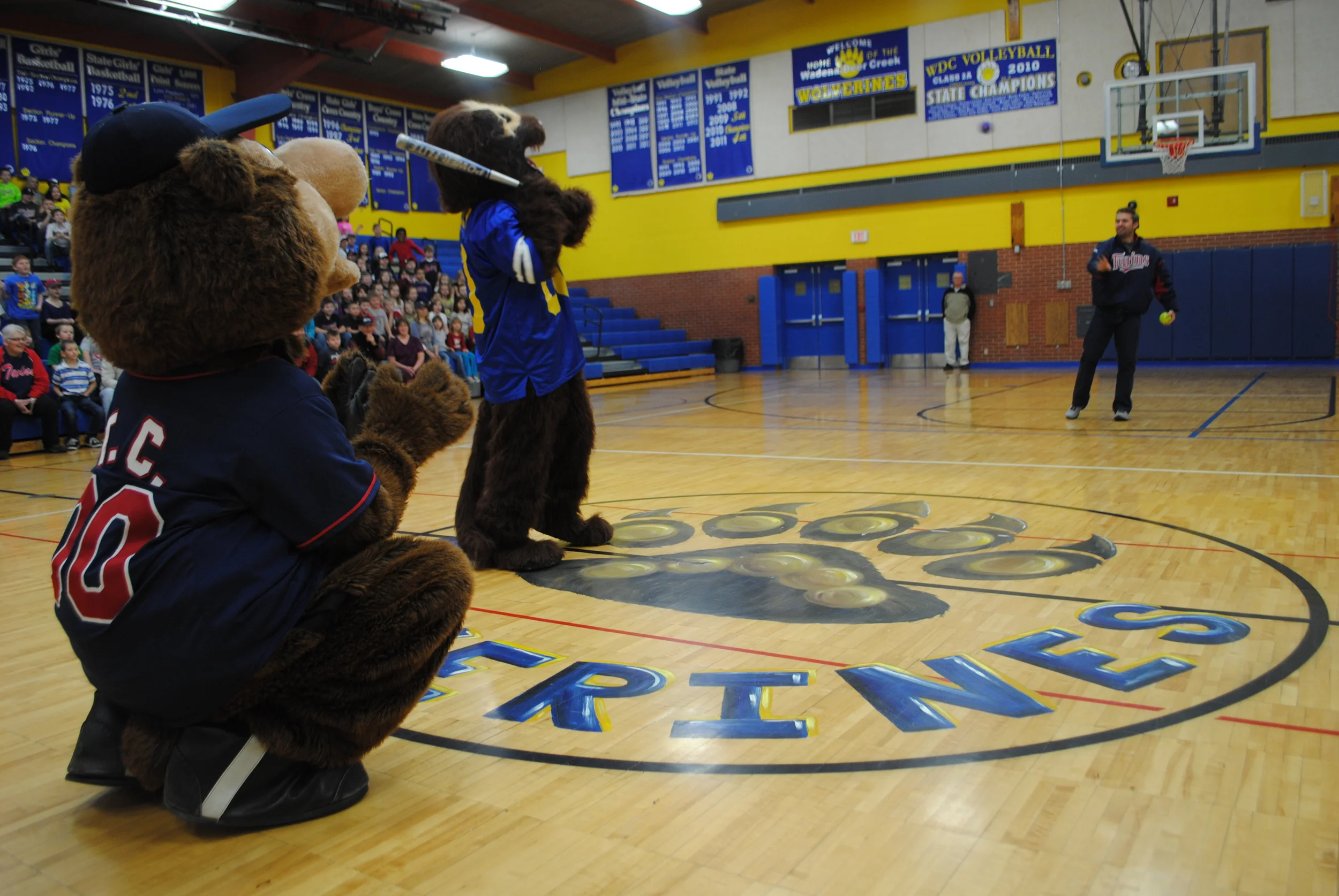 Brian Dozier pitches to Wooly the Wolverine during a friendly competition between Wooly and TC Bear during the MN Twins Caravan visit. Wooly and TC Bear both hit "home runs" during the contest.
