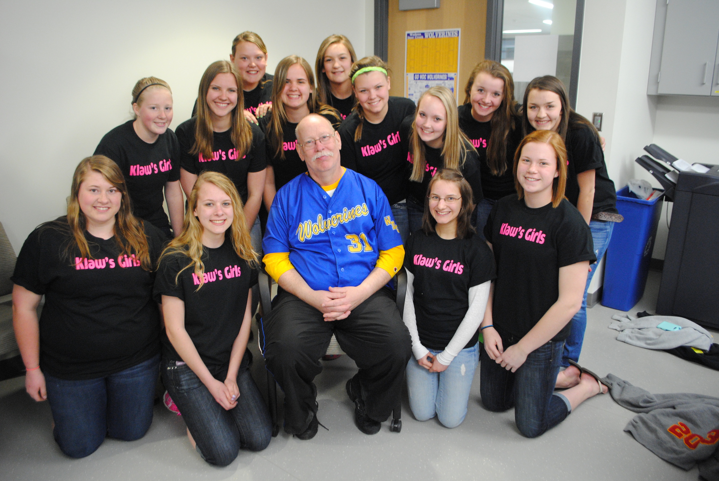 The WDC softball varsity and JV teams had T-shirts made for game days that read, “Klaw’s Girls” in honor of their beloved coach. Pictured with Mr. Klawitter is the JV team, from left, back row standing: Sarah Moen, Ashley Lehmkihl, Karon Johnson, Kayla Peters, Maggie Schmitz, MacKenzie Barthel, Mikena Formanek, Lauren Soroko, and Whitney Eickhoff; kneeling, from left: Kirsten Peterson, Taylor Dirks, Klawitter, Sandra Kucharczyk, and Kelsie Pierce. (Photo by Dana Pavek, WDC Schools)