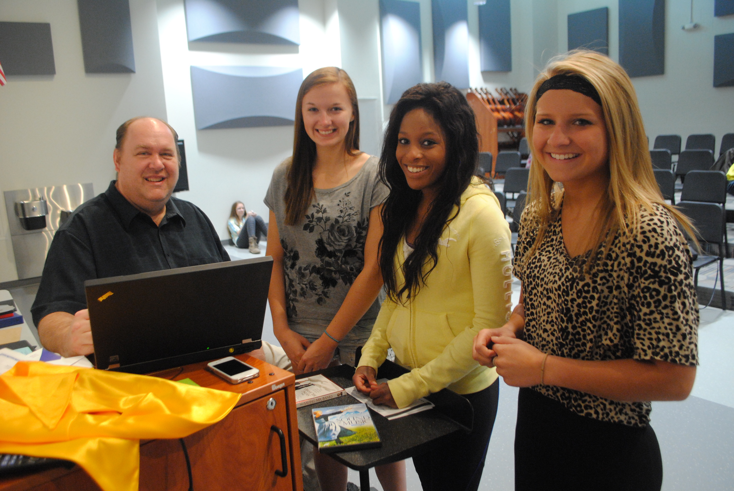 Mike Ortmann goes over attendance with choir students Mikaela Nordlund, Lacey Malone and Madison Barthel. The students talked about how Mr. Ortmann is one of their favorite teachers. “It’s just cool,” they said. (Photo by Dana Pavek, WDC Schools)