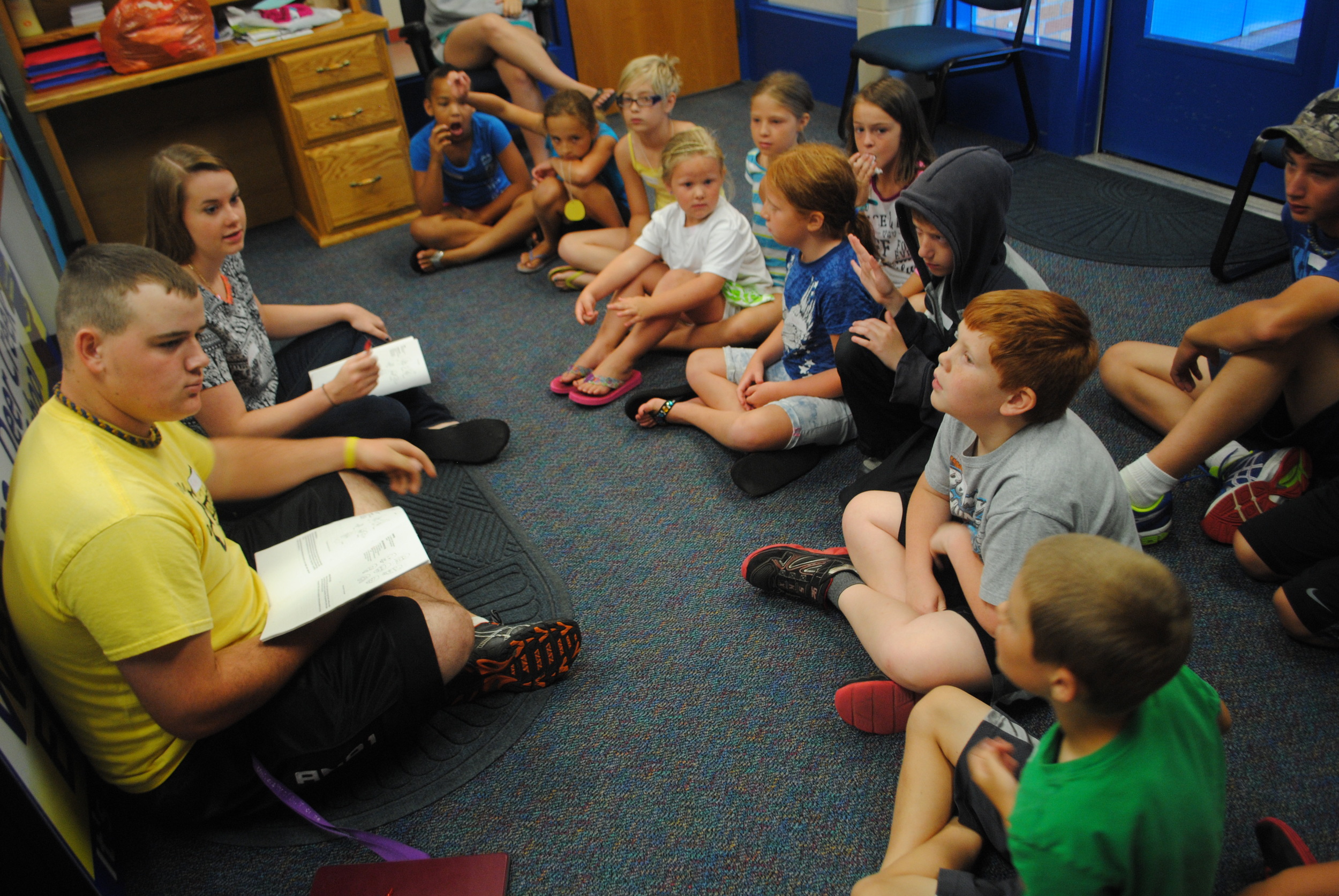 At left, Wadena-Deer Creek High School students Jennifer Craig and Ricky Price visit with youth about “good touches” received from family members, like hugs, high fives or knuckles, on July 22 at Wadena-Deer Creek Elementary. The discussion was part of the Red Flag Green Flag People program. (Photos by Dana Pavek, WDC Schools)