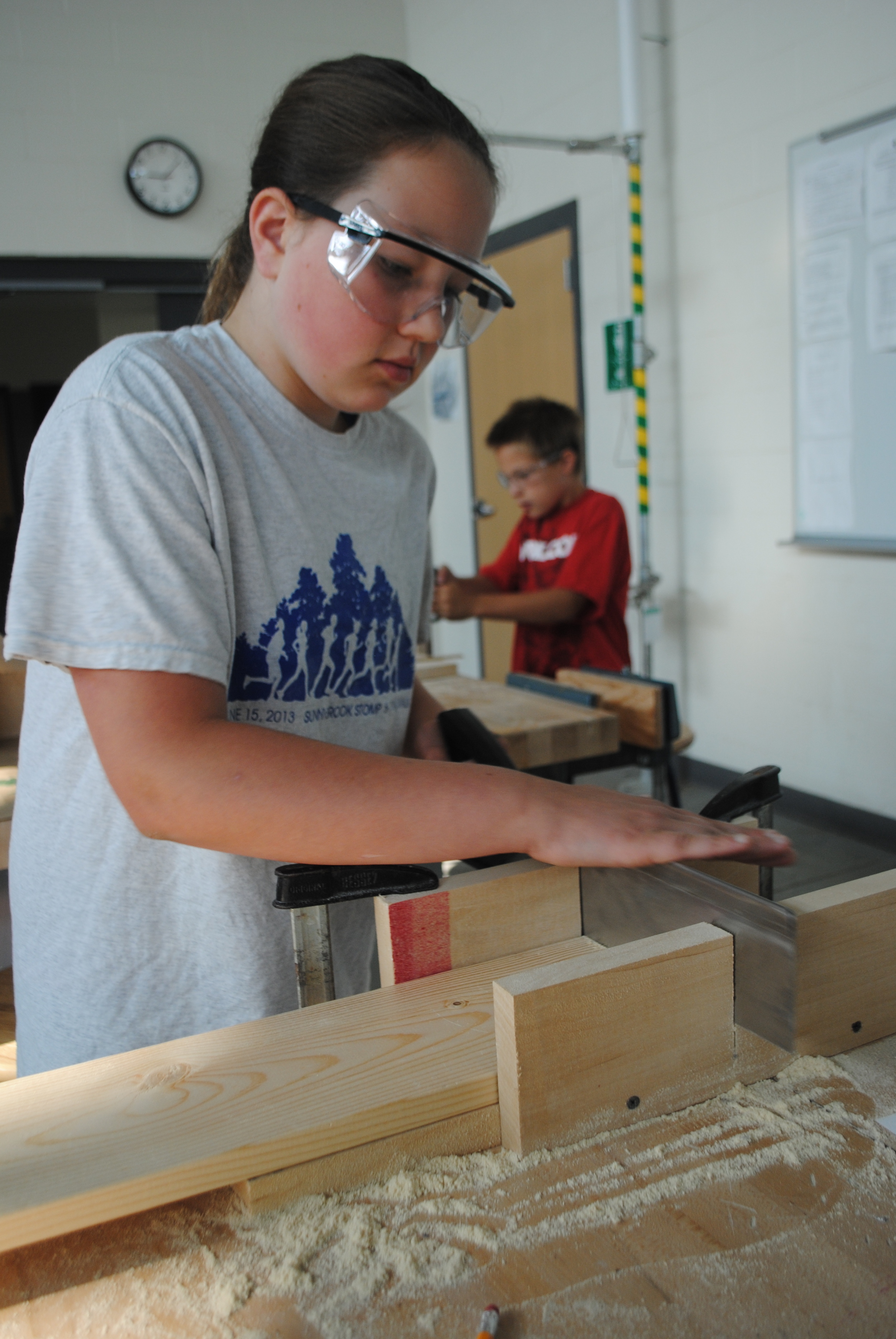 Kaylin Lupkes carefully saws a pine board using a miter box during the “Building Birdhouses for Backyard Birds.”