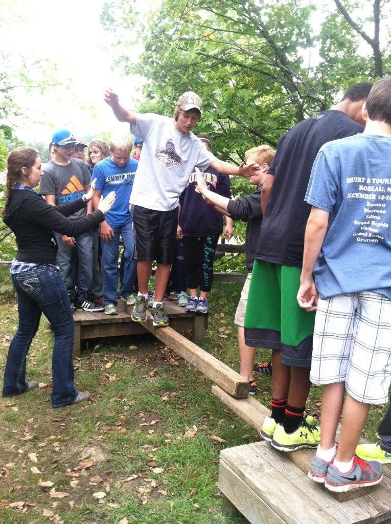 WDC seventh-grader Dylan Kern tries to walk across a beam while his classmates steady the beam and boards during a retreat Sept. 9 at Inspiration Point and Retreat Center near Clitherall. The group activities promote teamwork and provide skills for supporting each other. (Photo by Toni Kraska, WDC Schools)