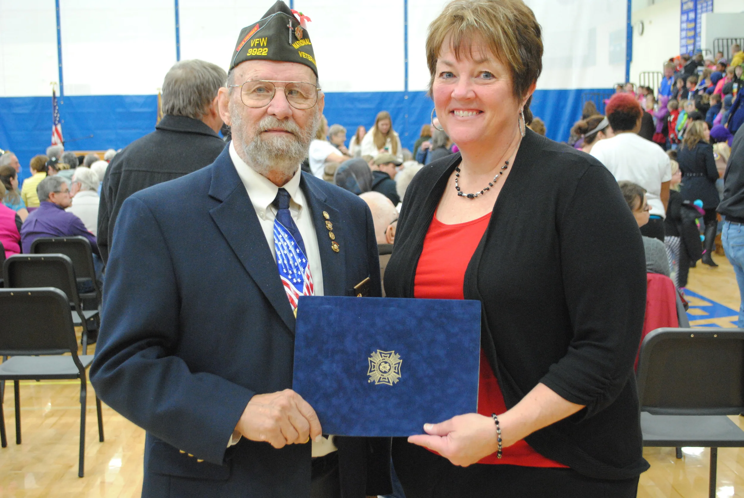 Wadena-Deer Creek Elementary teacher, Junelle Jackson, received her VFW Citizenship Education Teacher of the Year award from Jim White, Wadena VFW representative at the school’s Veterans Day program. Jackson’s award nomination was forwarded to the District level and she recently learned she’d won and will advance to the state competition. (Photo by Dana Pavek, WDC Schools)