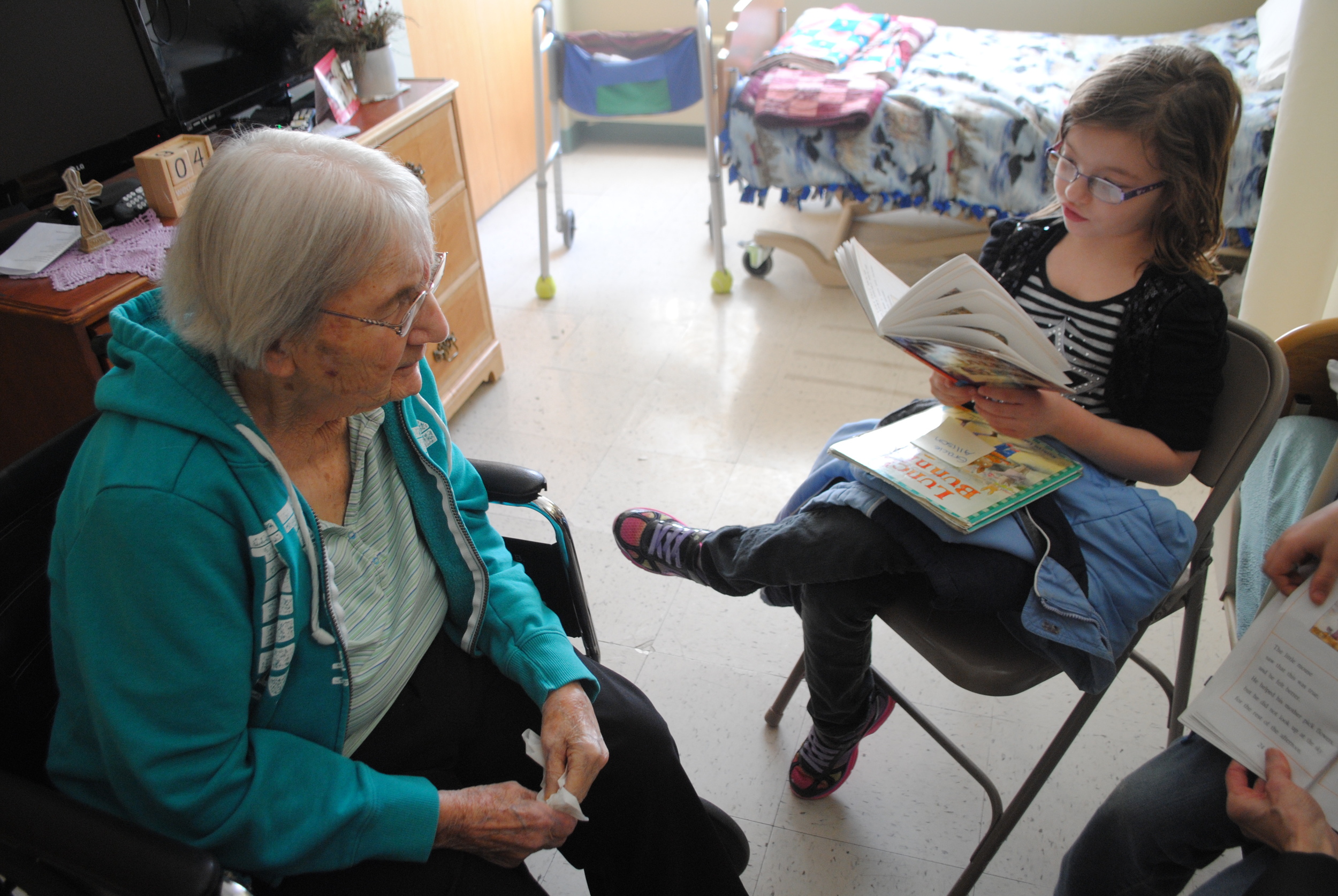 Gracie Ames, right, reads “Mouse Tales” to Maxine Bailey, a resident at Fair Oaks Lodge. 