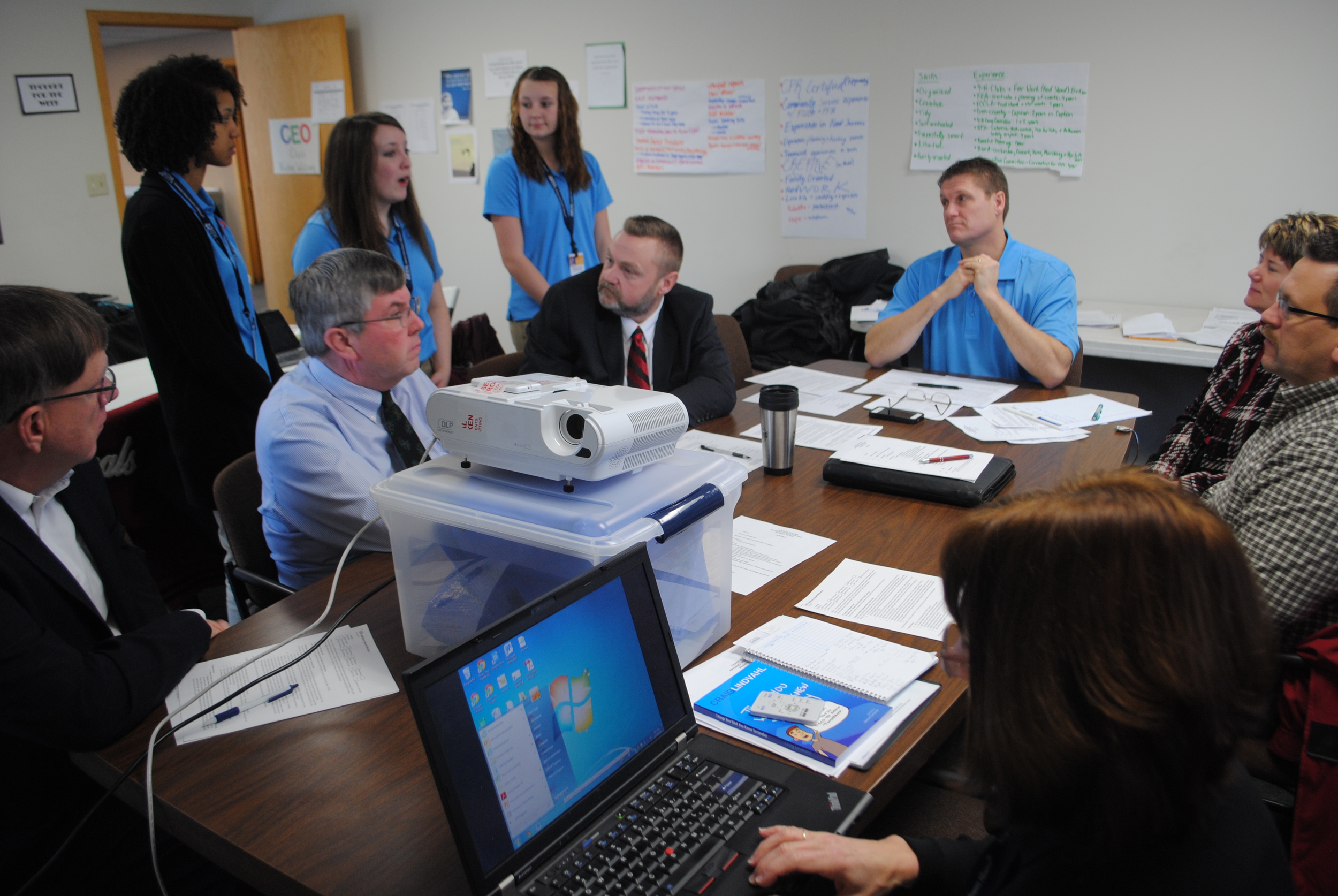Members of the Central MN CEO Advisory Board listen to CEO students give an update on their class. The program meets at different businesses in Wadena and Staples throughout the school year. Here, they are meeting in a conference room at Kal’s Cars in Wadena.