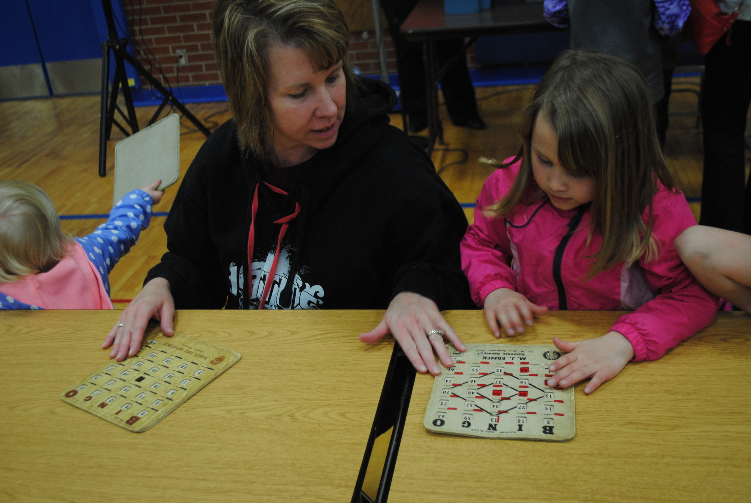 Lisa Leeseberg checks her daughter Aubrey’s bingo card during “Book Bingo” at WDC’s Ice Cream for Books event. Bingo winners were able to choose a new book from a huge selection of titles.