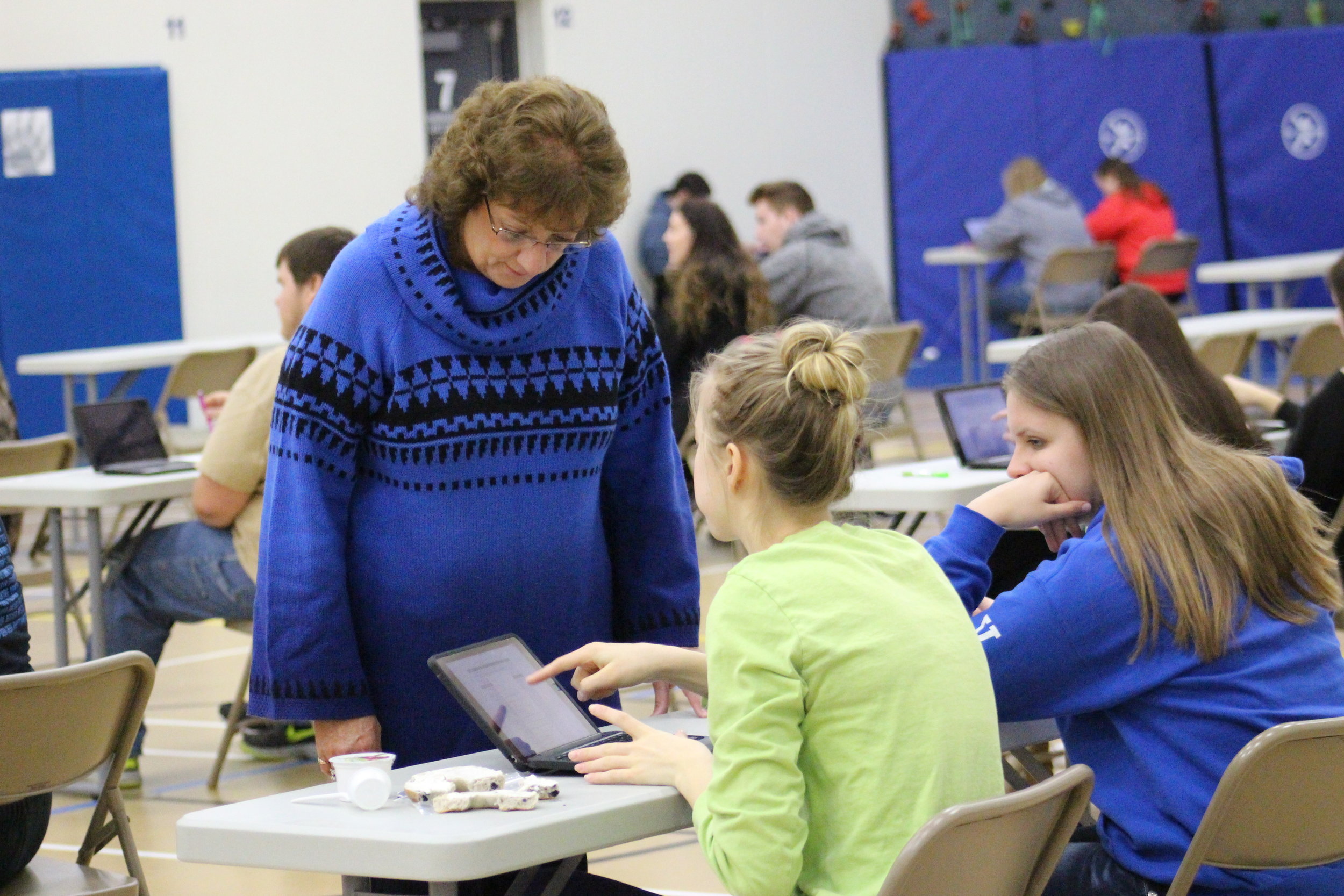 Nancy Rach assists Liz Peterson with a question before the start of the NCRC test this morning in the Auxiliary Gym.