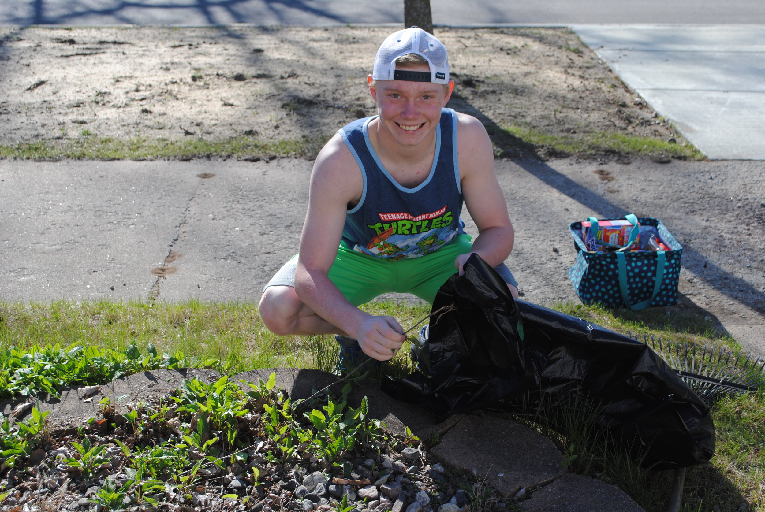 Preston Warren cleans a flower garden for an elderly resident last year.