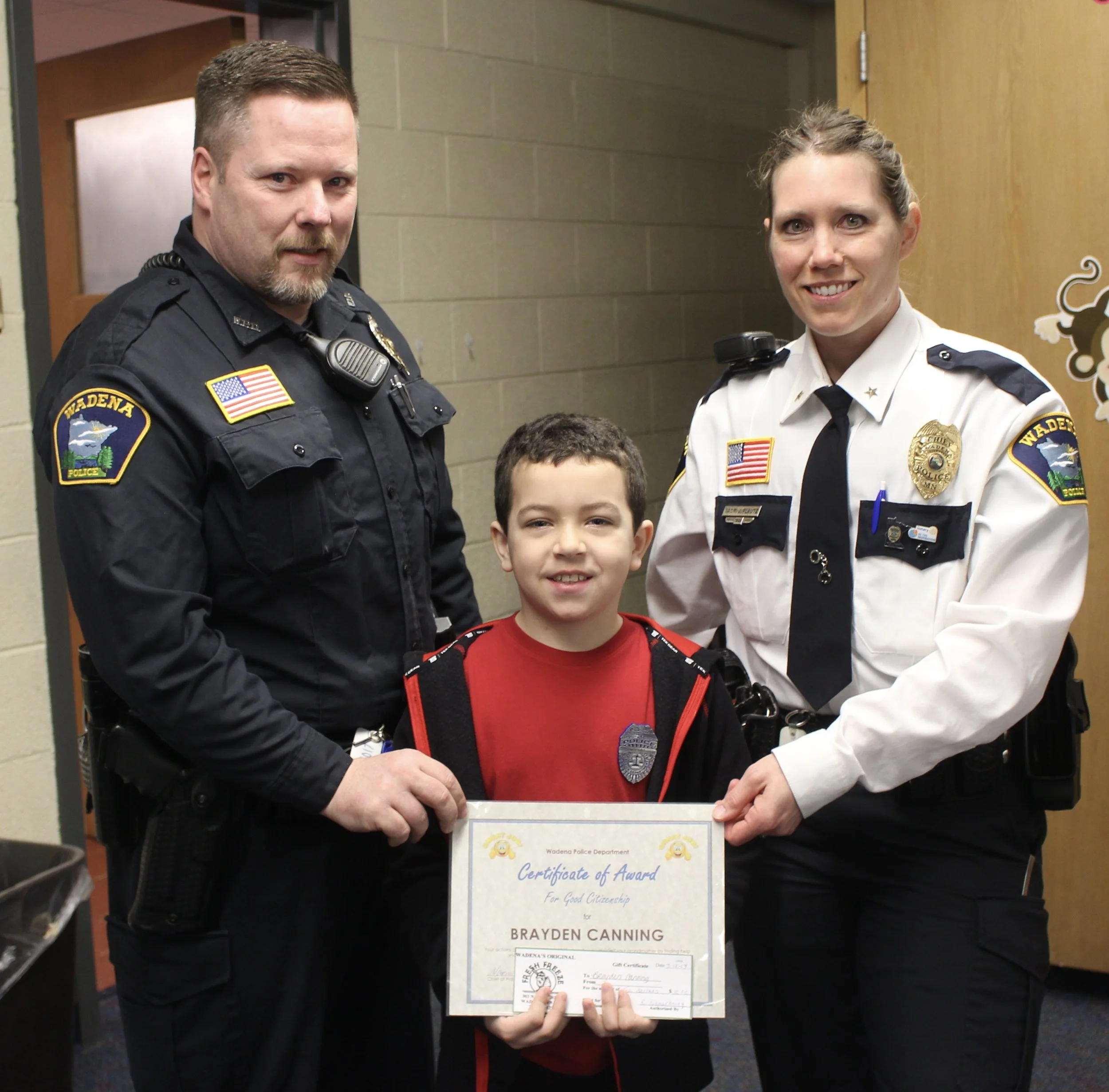 Wadena-Deer Creek second-grader Brayden Canning displays his Citizenship Award presented to him by Wadena Police Chief Naomi Plautz, right, and School Resource Officer Nick Grabe for his quick thinking and bravery. Photo by Dana Cantleberry, WDC Schools.
