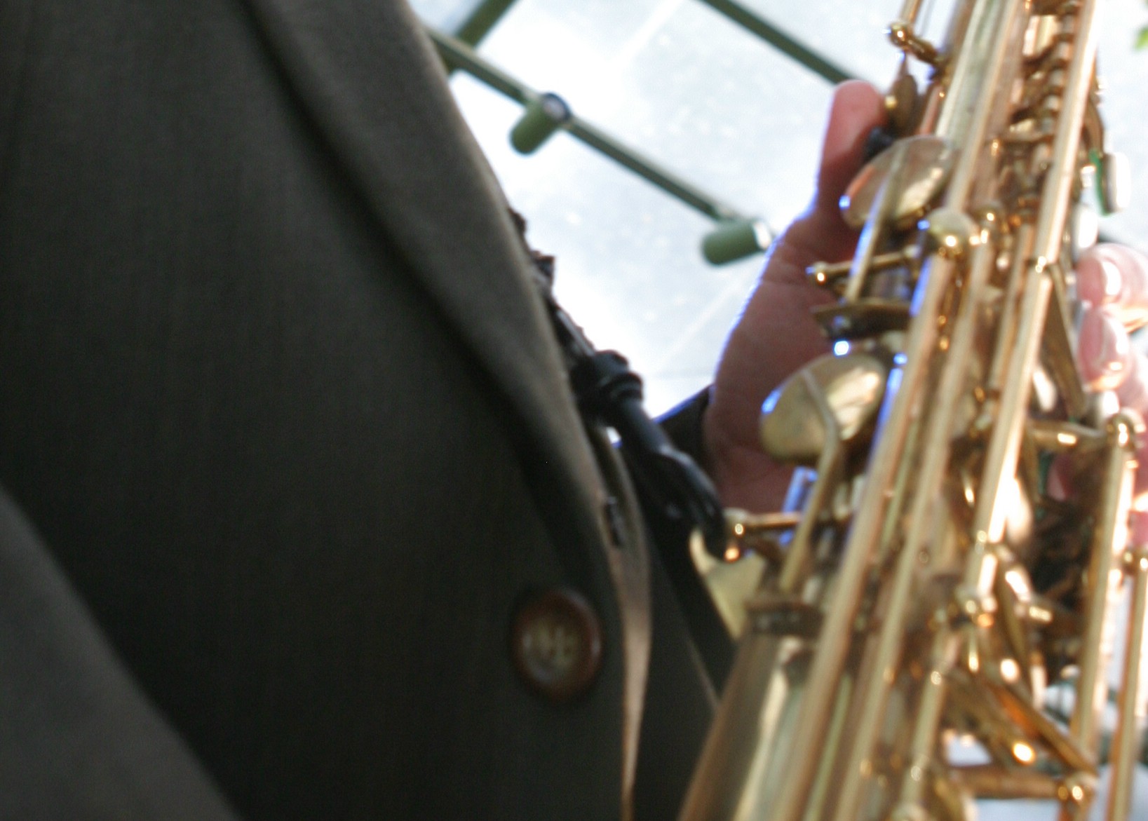    A close-up photo of person holding and playing saxophone.   
