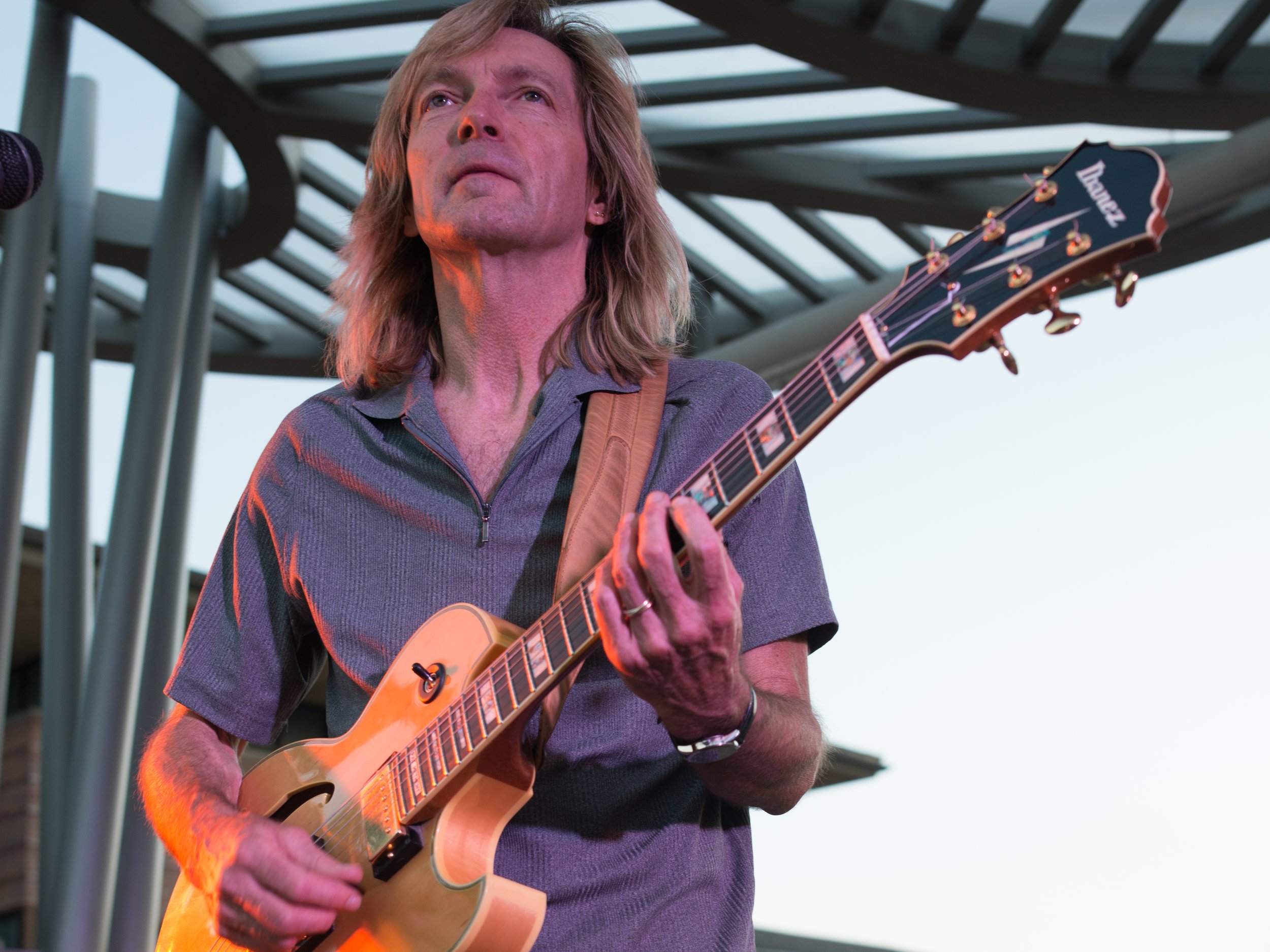    Bill Sickles performs on electric guitar at an outdoor event in Denver Colorado.   