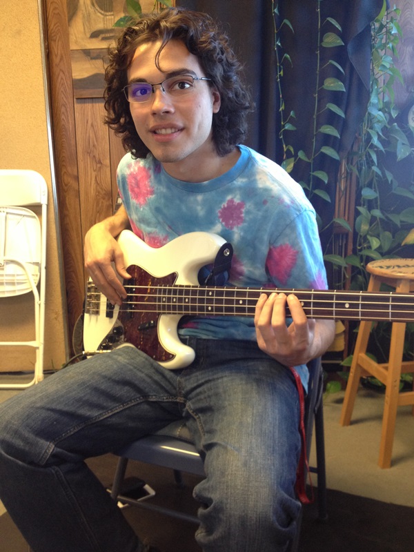    A teen boy poses with bass guitar   