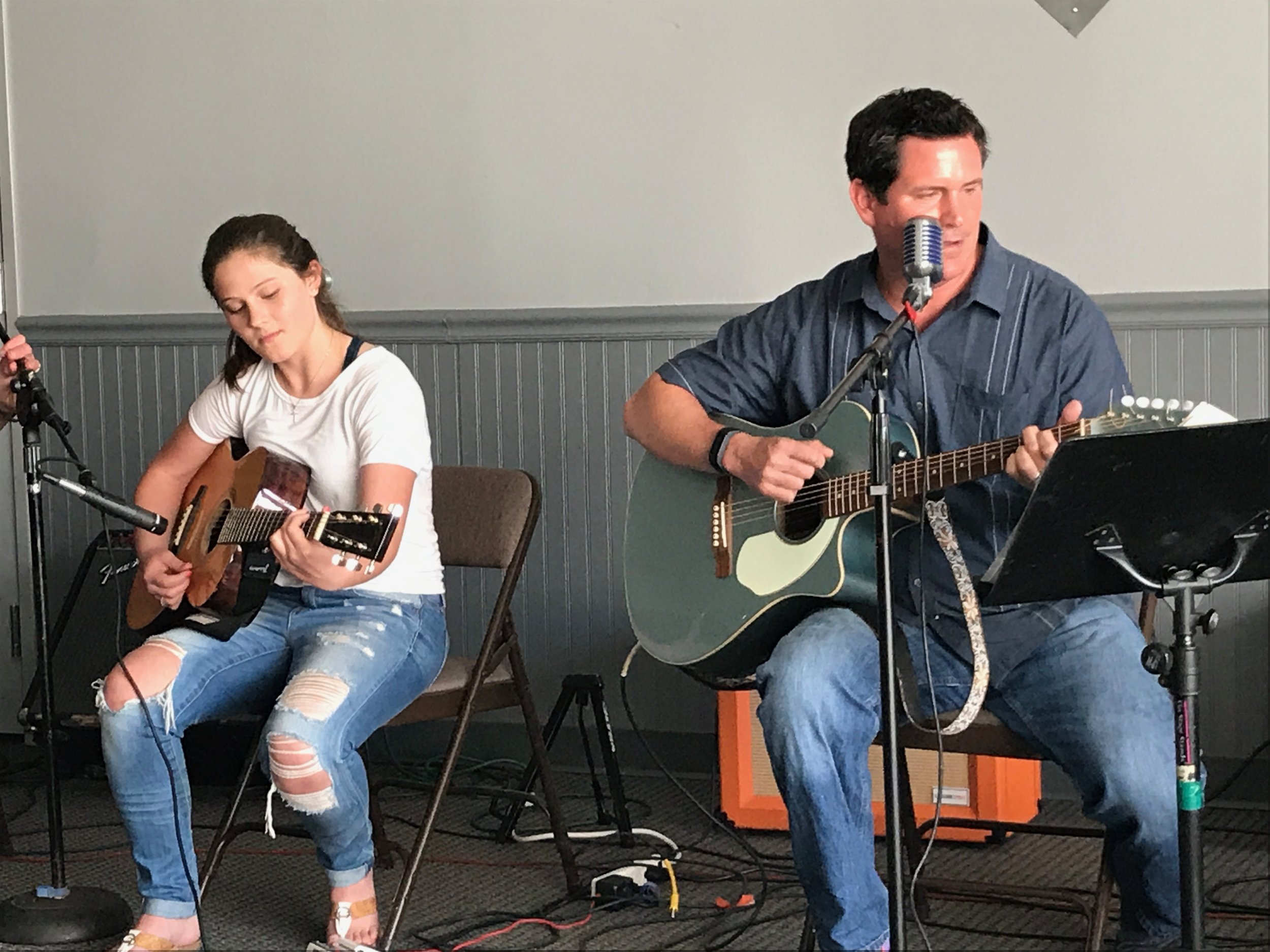    Adult and teenager play guitar and  perform together   