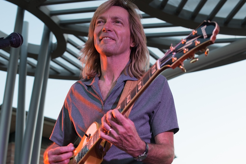  Bill Sickles performing solo guitar at summer concert event. 