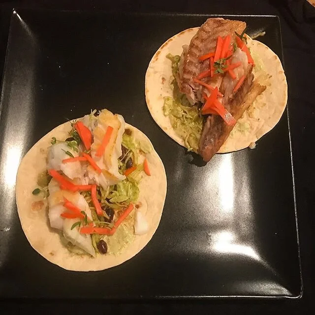 Duo of fish tacos, one with red snapper and the other cod. With a lime creme, salsa verde dressed slaw, soy beans, pickled radish and fresh spicy orange and lemon thyme. #pantryandfridge