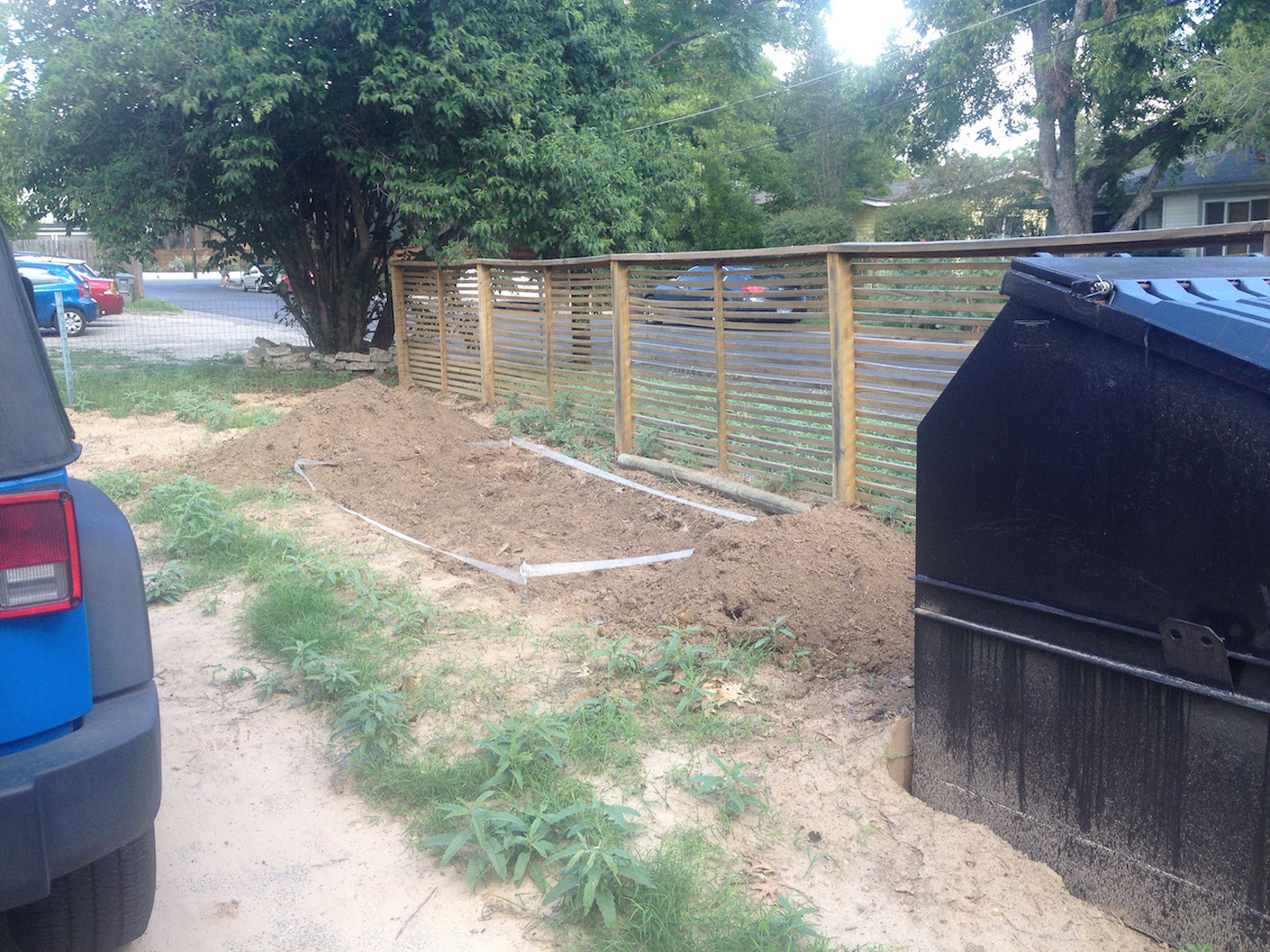Digging up dirt behind the dumpster.