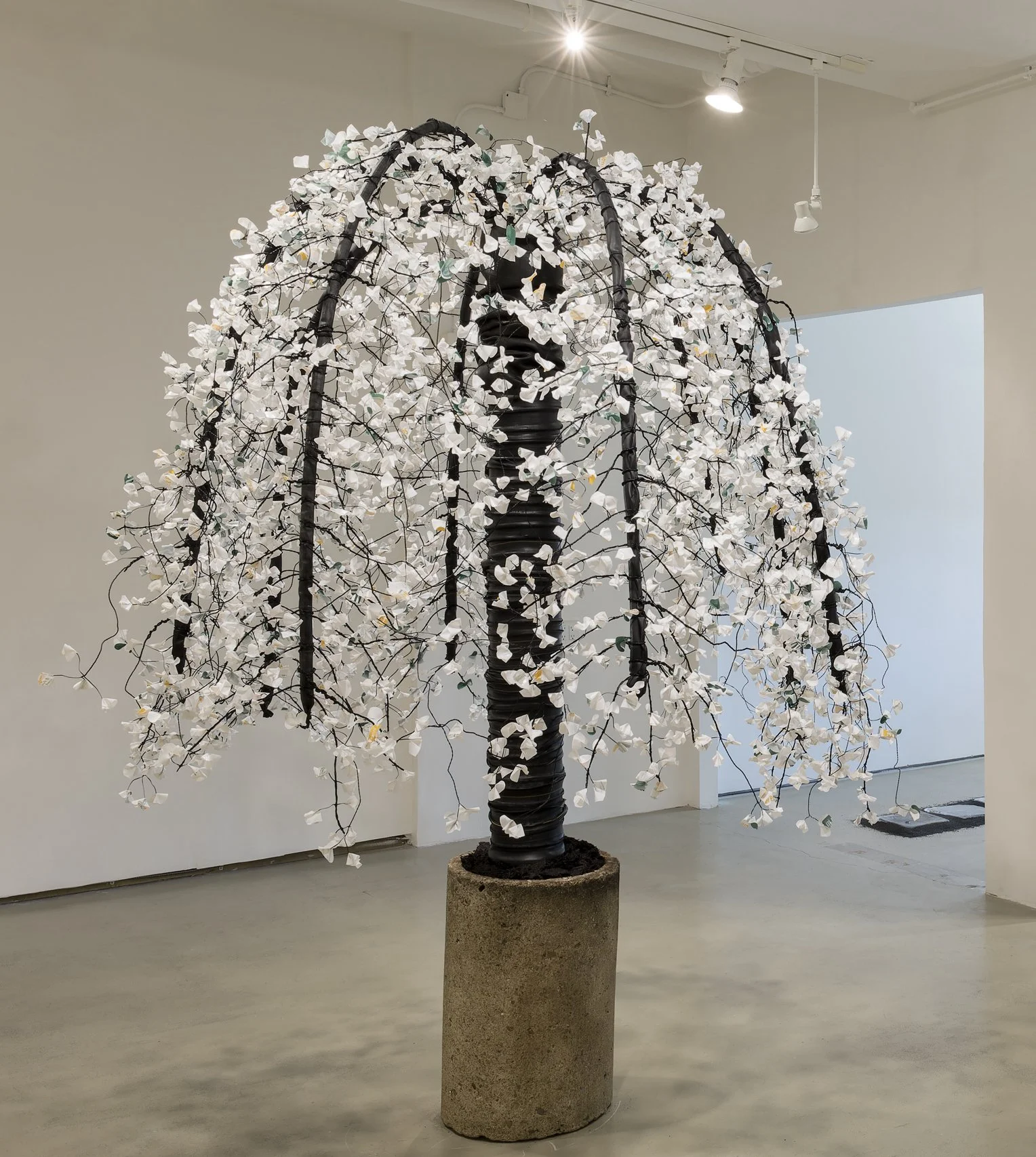  Salvaged bicycle inner tubes, upcycled pellet stove bags, pvc, coated wire and recovered concrete slug. Approx 96” x 60”, 2024, Ann St Gallery Installation view.  Photo credit: Ann Street Gallery 