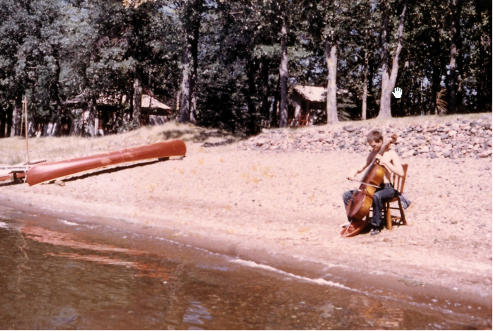 Arthur Russell playing cello on a beach in Minnesota, circa September 1971. Photograph by Charles Arthur Russell Sr. Courtesy of Charles Arthur Russell Sr. and Emily Russell.