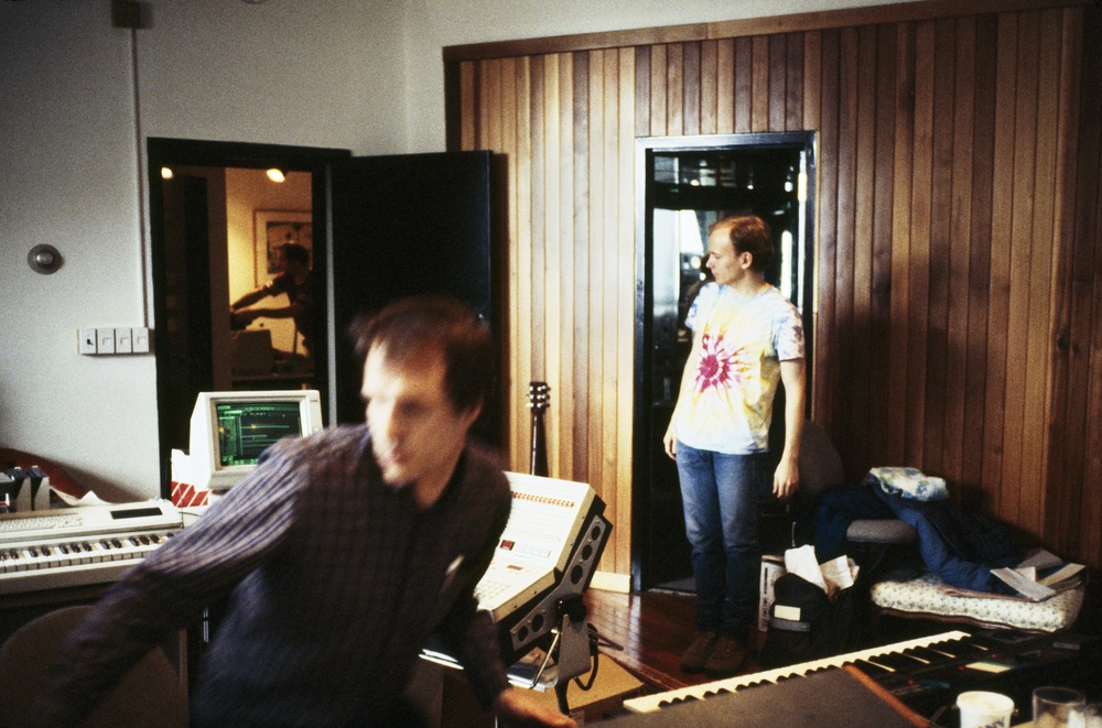   Arthur Russell recording music at Battery Sound in the early 1980s. Eric Muiderman, student of Peter Zummo and an apprentice of Arthur, stands on the right. Mark Freedman works in the adjoining room. Photograph by and courtesy of Peter Zummo.&nbsp;