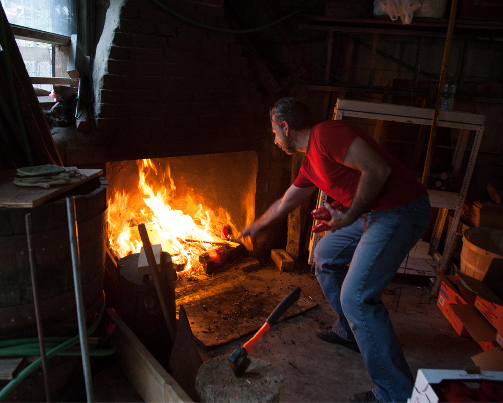CARMELO GALLÉ ROASTING PEPPERS IN THE FAMILY GARAGE. 