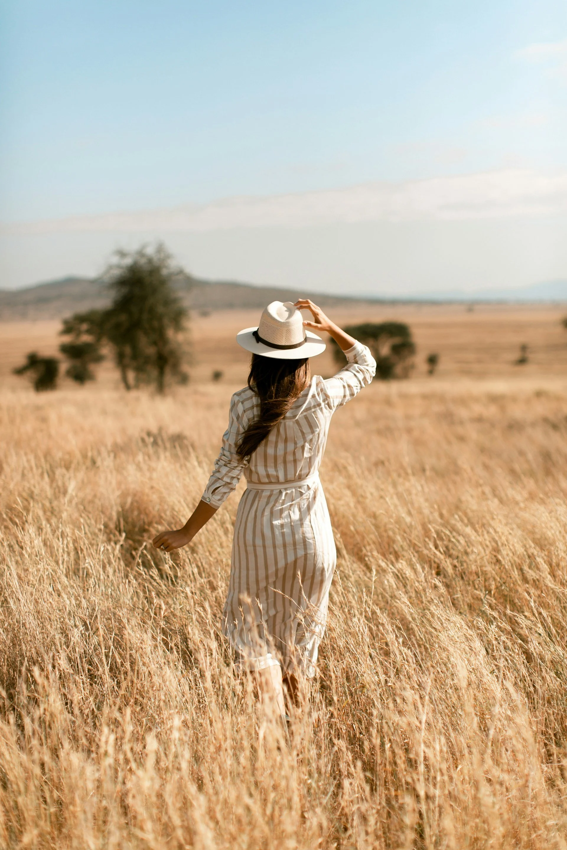 Woman walking freely through an open grassy field